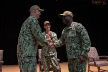 210729-N-IG466-0173 NAVAL SUPPORT ACTIVITY BAHRAIN (July 29, 2021) – Capt. Christopher Gilbertson, left, outgoing commander of Destroyer Squadron (DESRON) 50 and Task Force (TF) 55, shakes the hand of Capt. Robert Francis, right, incoming commander of DESRON 50 and TF 55, after relinquishing authority during a change of command ceremony presided over by Vice Adm. Brad Cooper, center, commander, U.S. Naval Forces Central Command, U.S. 5th Fleet and Combined Maritime Forces, onboard Naval Support Activity Bahrain, July 29. DESRON 50 and TF 55 operate in the U.S. 5th Fleet area of operations in support of naval operations to ensure maritime stability and security in the Central Region, connecting the Mediterranean and Pacific through the western Indian Ocean and three critical chokepoints to the free flow of global commerce. (U.S. Navy photo by Mass Communication Specialist 2nd Class Adelola Tinubu)