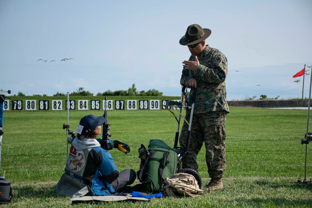 A U.S. Marine with the United States Marine Corps (USMC) Shooting Team, coaches a junior shooter with the Civilian Marksmanship Program (CMP) during the USMC Shooting Team’s Junior Clinic at Camp Perry, Ohio, July 31, 2021. The purpose of the clinic was for the USMC Shooting Team to teach junior shooters with the CMP the fundamentals and safety procedures of competitive shooting. (U.S. Marine Corps photo by Cpl. Nello Miele)