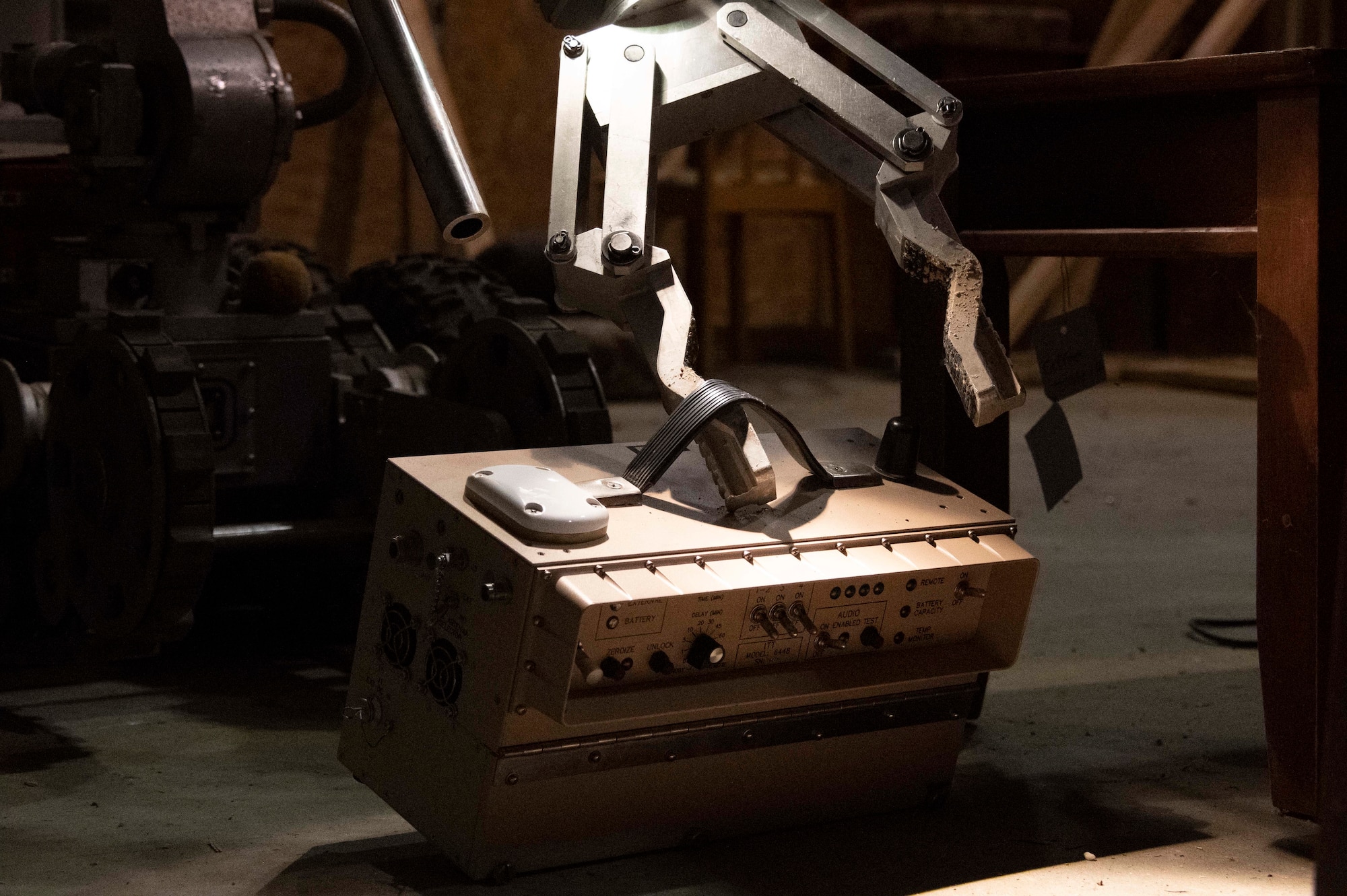 A remote controlled robotic crane lifts an old radio.