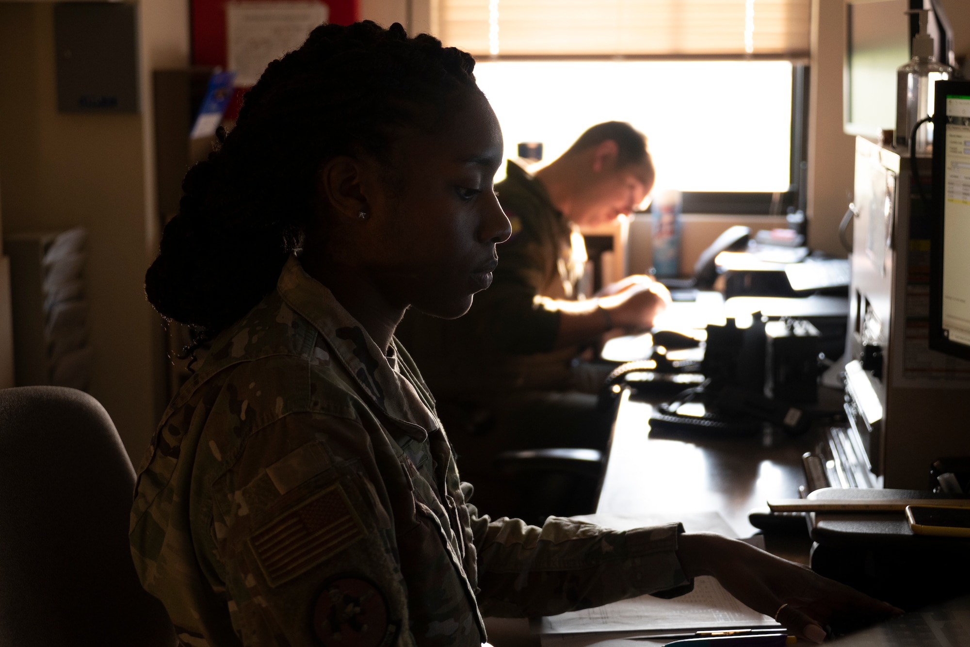 A woman and a man sit behind a desk