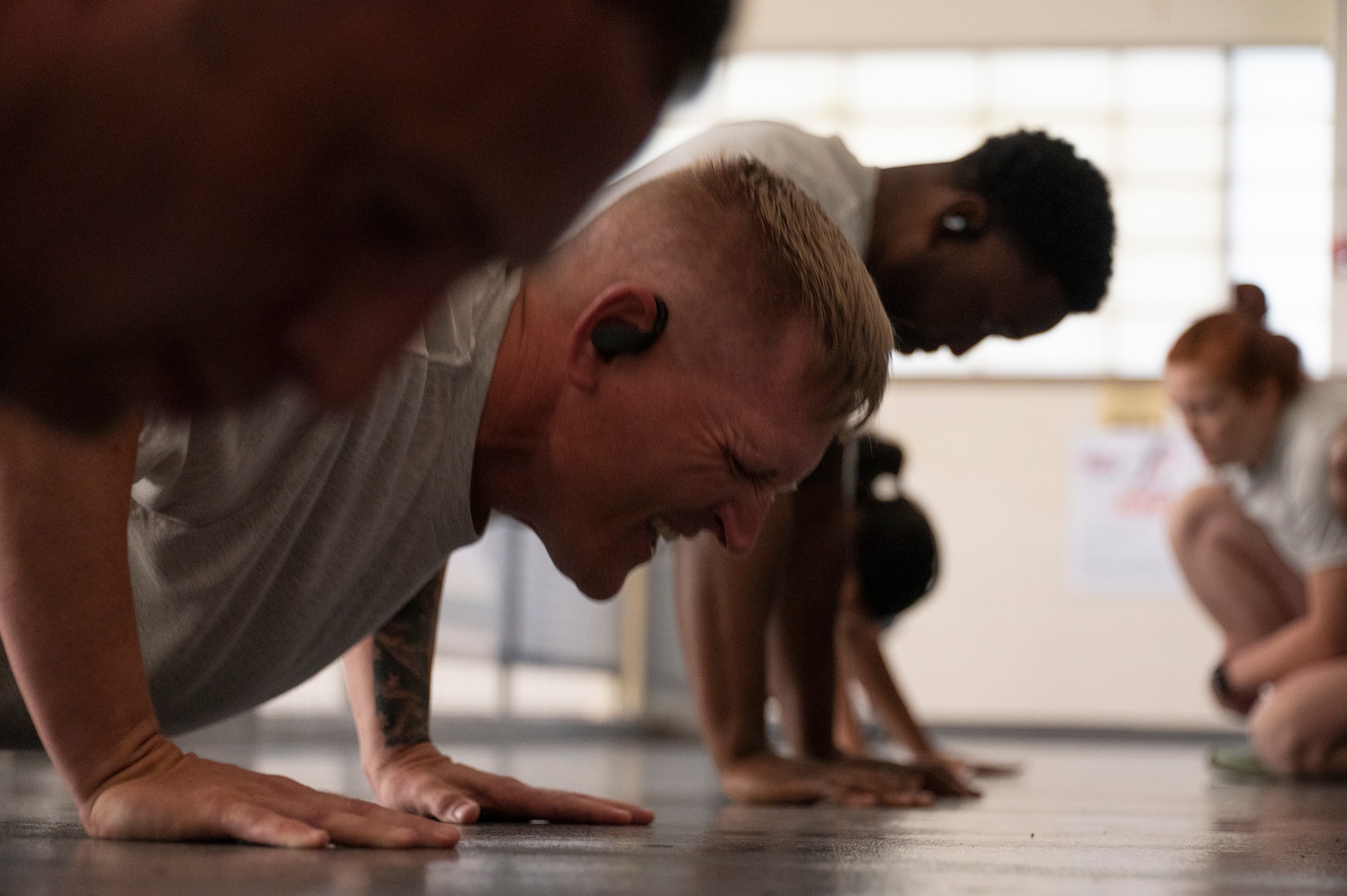 Four Airmen perform push-up exercises.