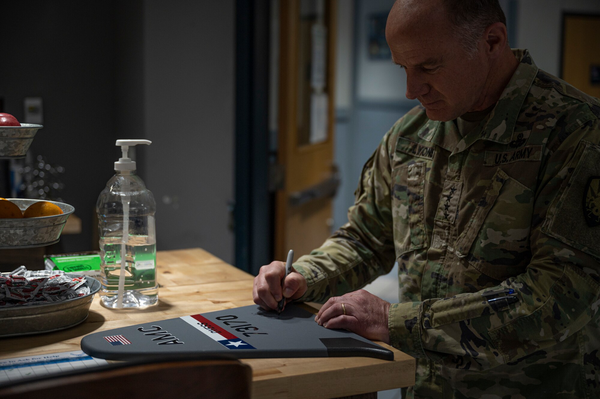 U.S. Army Gen. Stephen R. Lyons, U.S. Transportation Command commander, signs a C-130J Super Hercules tail flash at Dyess Air Force Base, Texas, July 28, 2021. Traditionally, the 317th Airlift Wing requests distinguished visitors to sign a tail flash to commemorate their visit. (U.S. Air Force photo by Senior Airman Colin Hollowell)