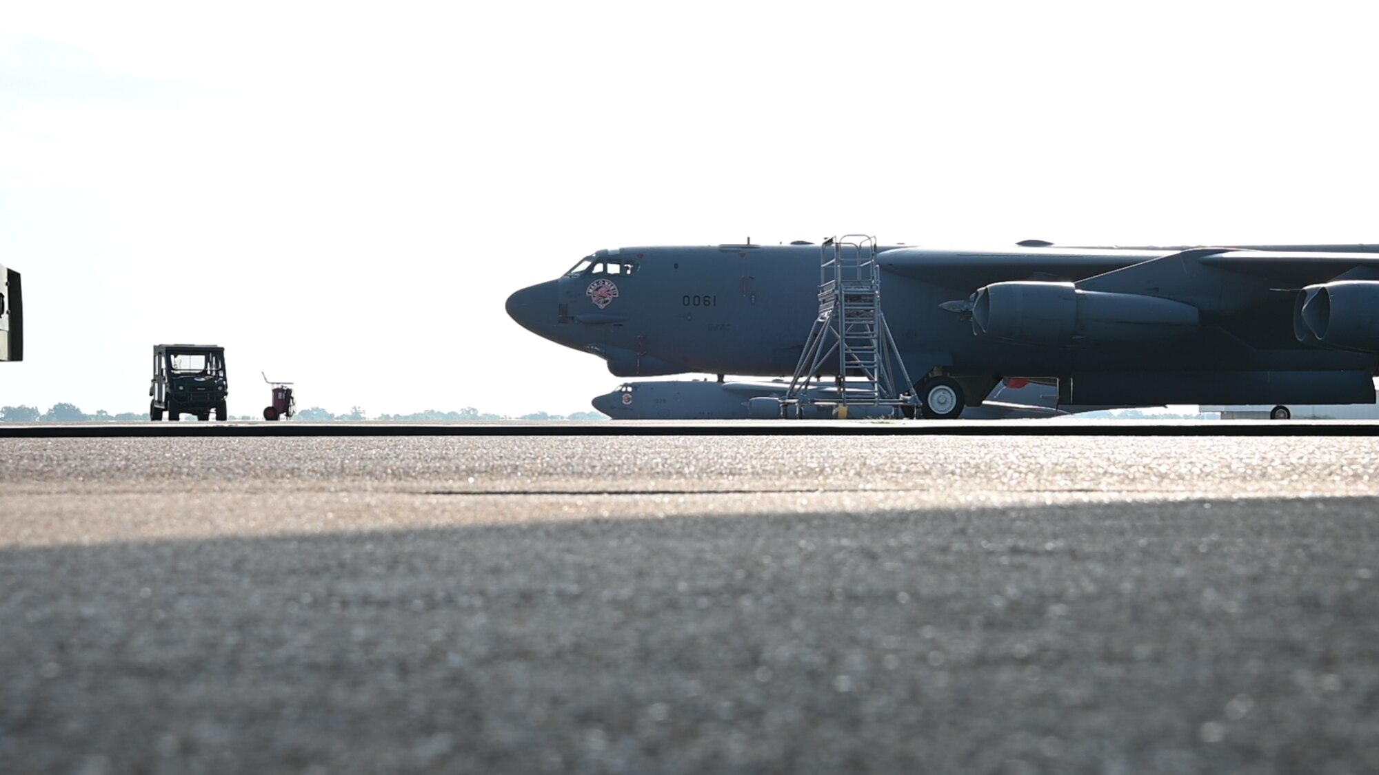 vehicle parked in front of airplane on flight line.