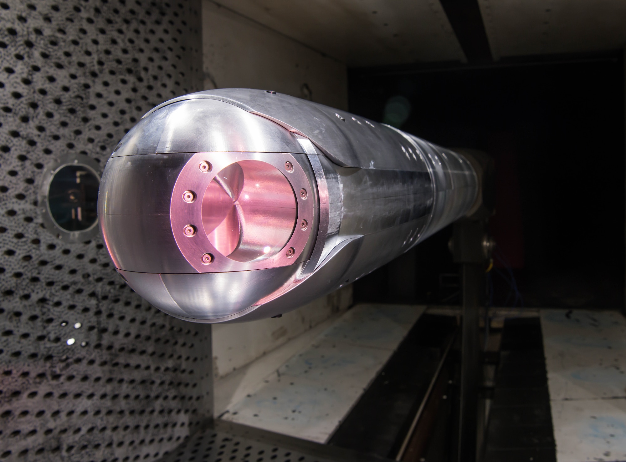 A directed energy (DE) system turret is positioned on a sting in the 4-foot transonic wind tunnel at Arnold Air Force Base for testing by the Aerodynamics Test Branch of Arnold Engineering Development Complex, March 5, 2021. Aero-optical wind tunnel testing of a DE system is a new capability for AEDC. (U.S. Air Force photo illustration by Jill Pickett)(The appearance of a glow from a laser was simulated for this photo.)