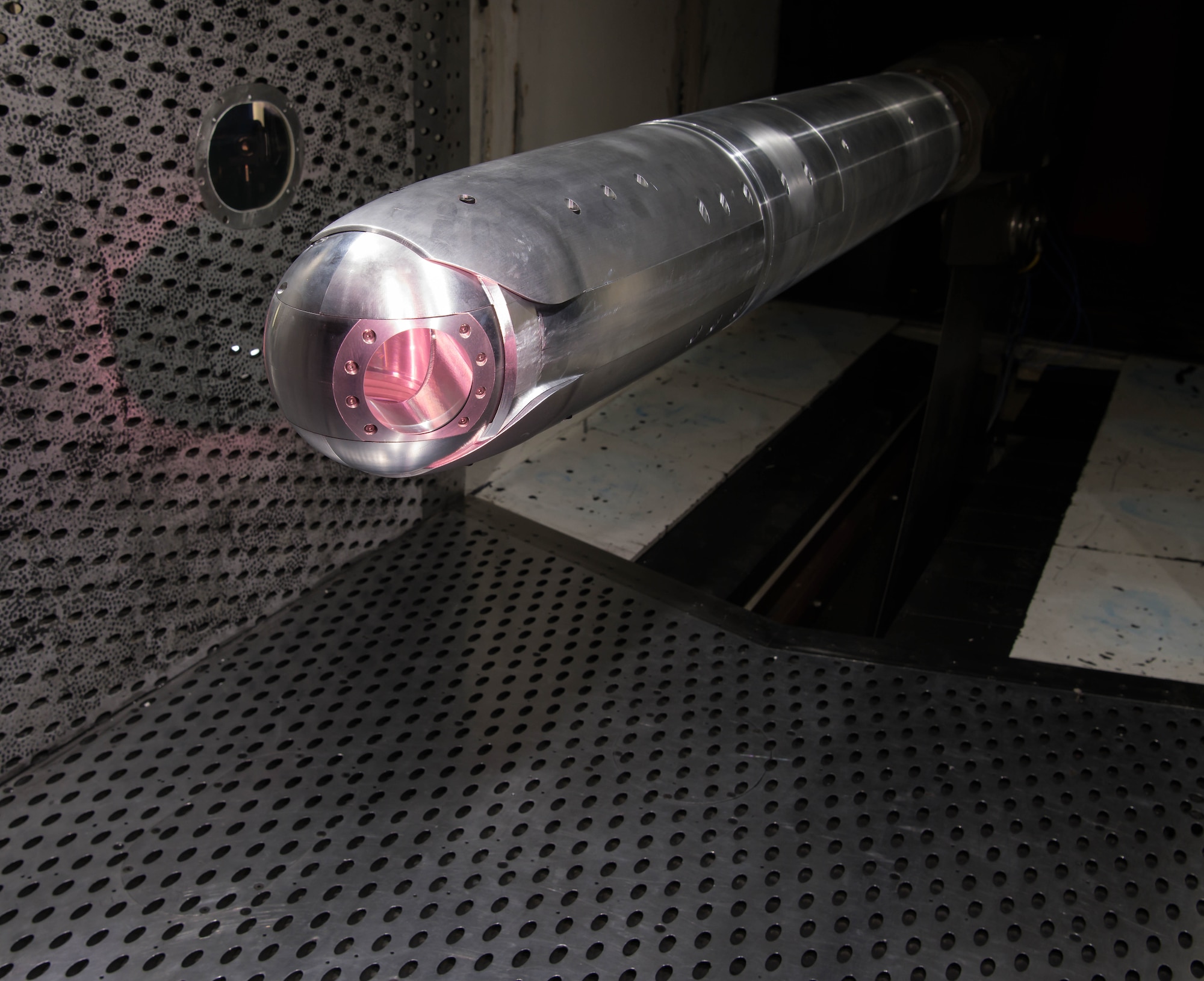 A directed energy (DE) system turret is positioned on a sting in the 4-foot transonic wind tunnel at Arnold Air Force Base for testing by the Aerodynamics Test Branch of Arnold Engineering Development Complex, March 5, 2021. Aero-optical wind tunnel testing of a DE system is a new capability for AEDC. (U.S. Air Force photo illustration by Jill Pickett)(The appearance of a glow from a laser was simulated for this photo.)