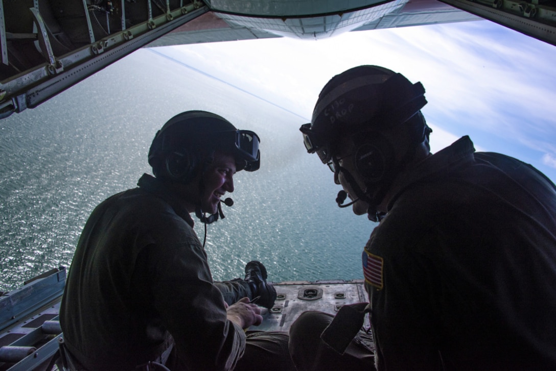 Coast Guard Petty Officer 3rd Class Tyler Bonebright and Petty Officer 2nd Class Mark Doerr, both aviation maintenance technicians at Coast Guard Air Station Clearwater, take part in training and conduct a drop of simulated emergency supplies on a C-130, 12 miles west of Anclote Key, Florida, June 29, 2021. During an actual emergency, crews will drop equipment and supplies to aid those in distress and help facilitate the rescue.