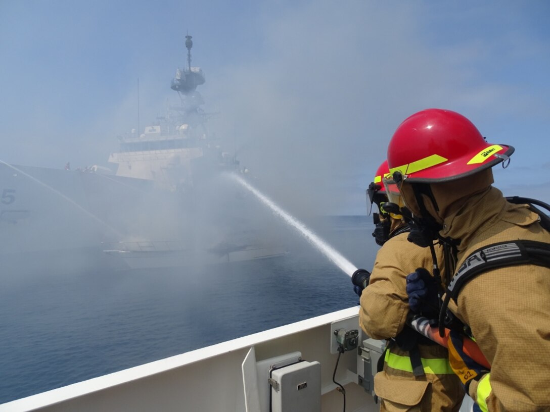 Coast Guard Cutter Benjamin Bottoms crewmembers work with Coast Guard Cutters Haddock and Munro to extinguish a vessel fire off the coast of San Diego, July 15, 2021. The vessel left the Oceanside harbor heading towards Carlsbad when it was seen on fire.