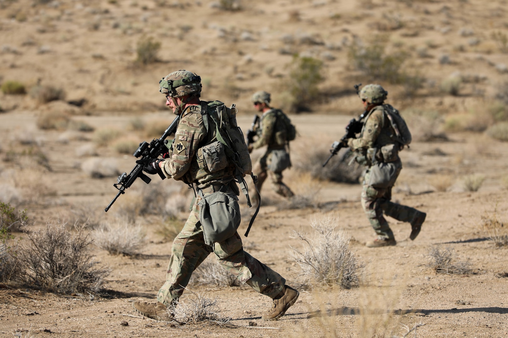 Soldiers with the 45th Infantry Brigade Combat Team, Oklahoma Army National Guard, move through the desert during a live-fire exercise at the National Training Center in Fort Irwin, California, July 24, 2021.
