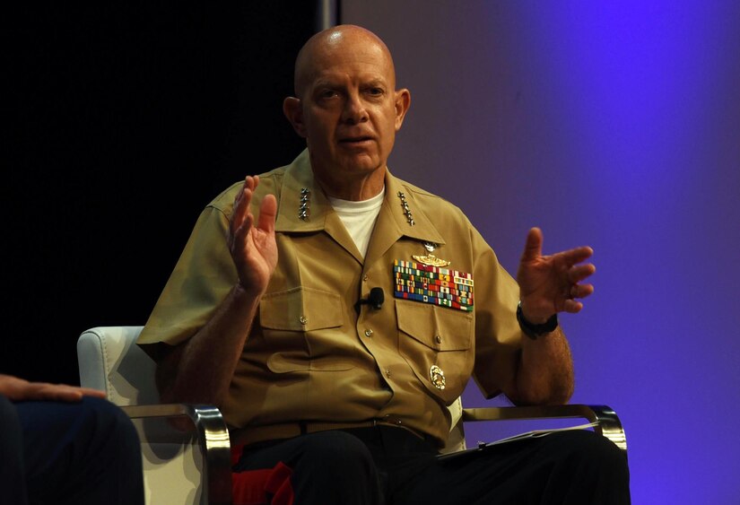 A man speaks while making a gesture with his hands to emphasize what he's saying.