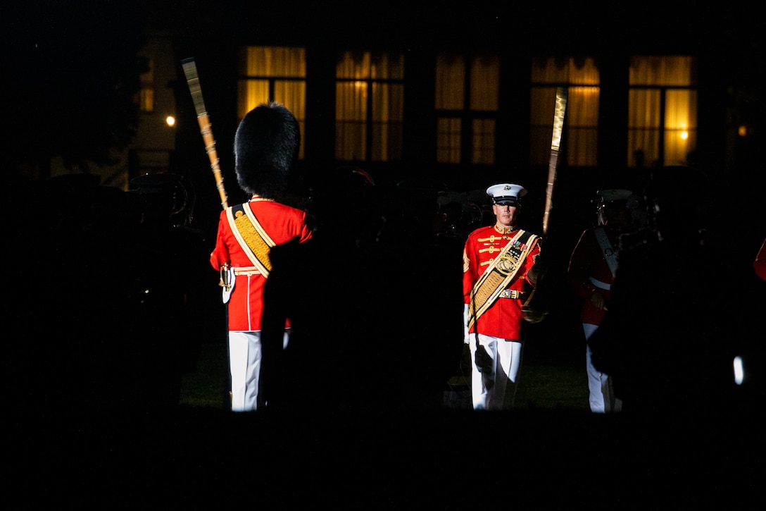 Master GySgt. Duane King, drum major, “The President’s Own,” U.S. Marine Band, left, and MGySgt. Keith Martinez, drum major, “The Commandant’s Own,” U.S. Marine Drum and Bugle Corps, right, perform during the Friday Evening Parade at Marine Barracks Washington, July 30, 2021.