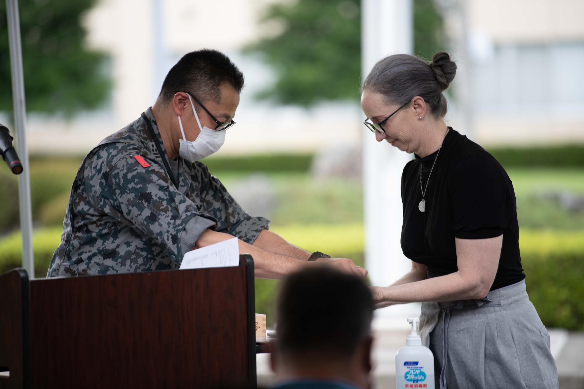 Japan Air Self Defense Commander Takashi Izuhara and Leslie Jones handle time capsule items.