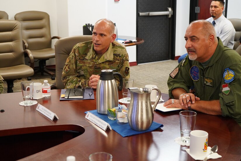 Col. Schaefer joins Maj. Gen. Kilian at conference table.