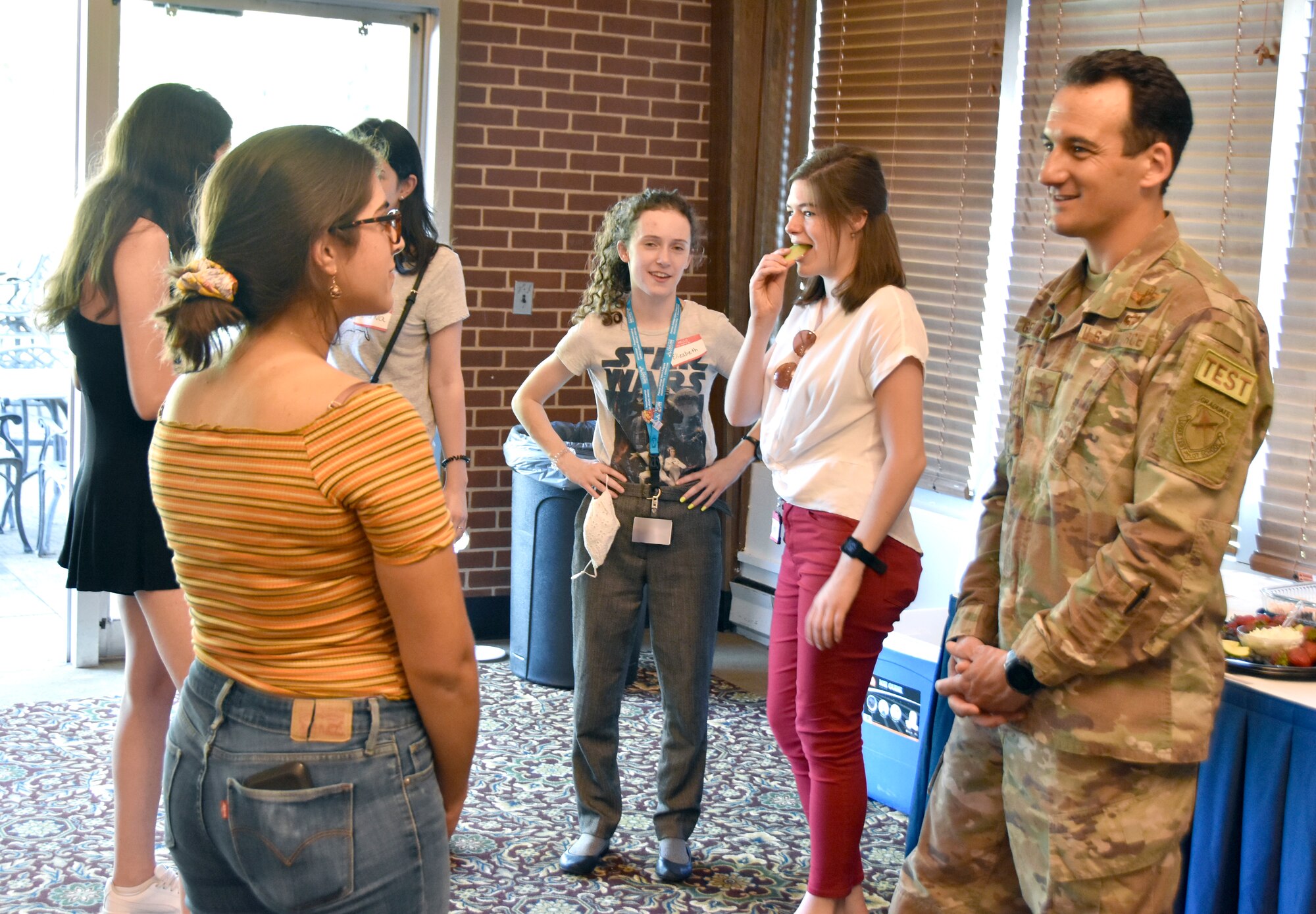 Maria Urdaneta, left, speaks with Col. Jeffrey Geraghty, right, Arnold Engineering Development Complex commander, at a social event June 17, 2021, at the Arnold Lakeside Complex on Arnold Air Force Base, Tenn., held as part of the summer internship program. Leadership with the Department of Defense and National Aerospace Solutions, LLC, were in attendance to welcome the interns. (U.S. Air Force photo by Bradley Hicks) (This image has been altered by obscuring badges for security purposes.)