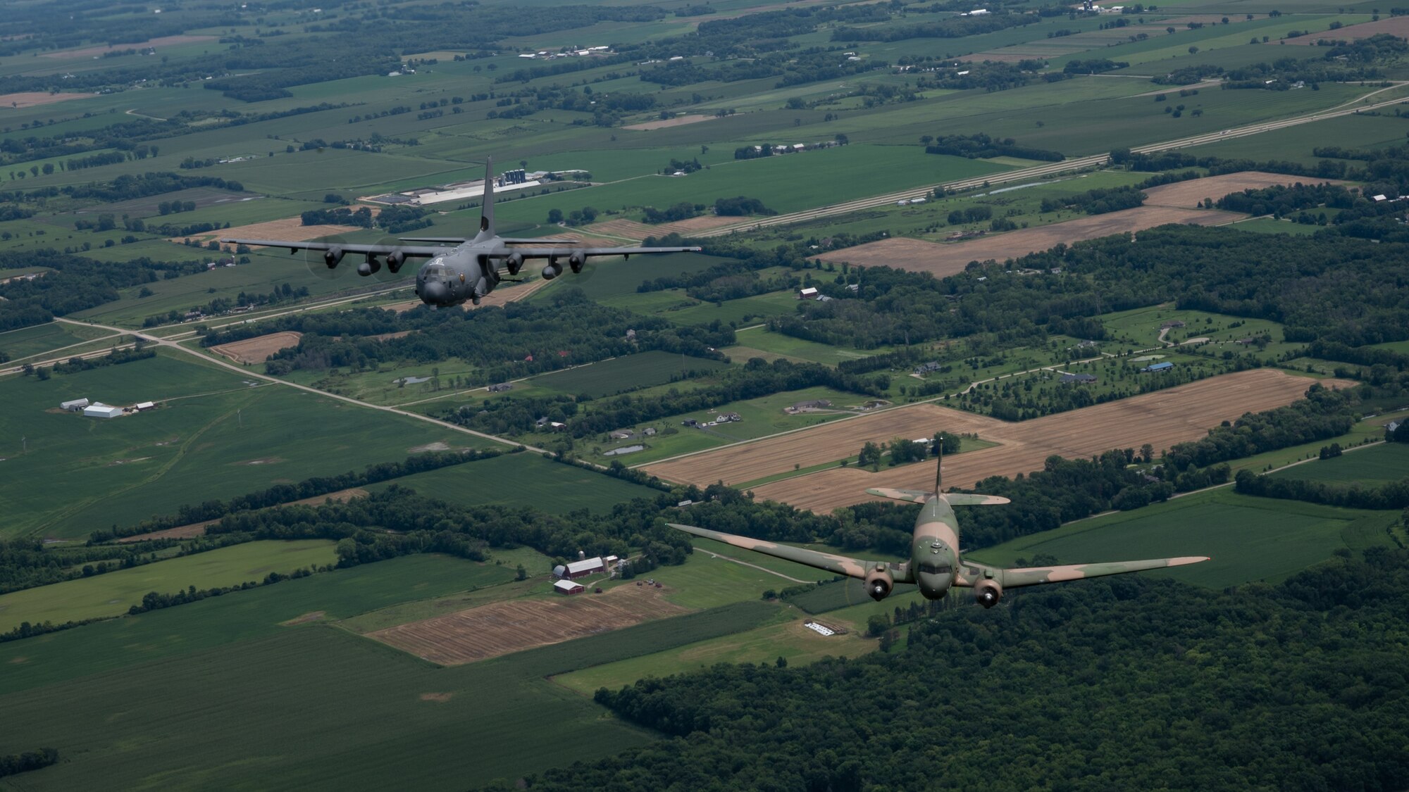 An AC-47 from Topeka, Kansas, and an AC-130J Ghostrider from the 4th Special Operations Squadron at Hurlburt Field, Fla., conduct a gunship legacy flight during EAA AirVenture Oshkosh 2021, around Wittman Regional Airport, Wis., July 30, 2021.