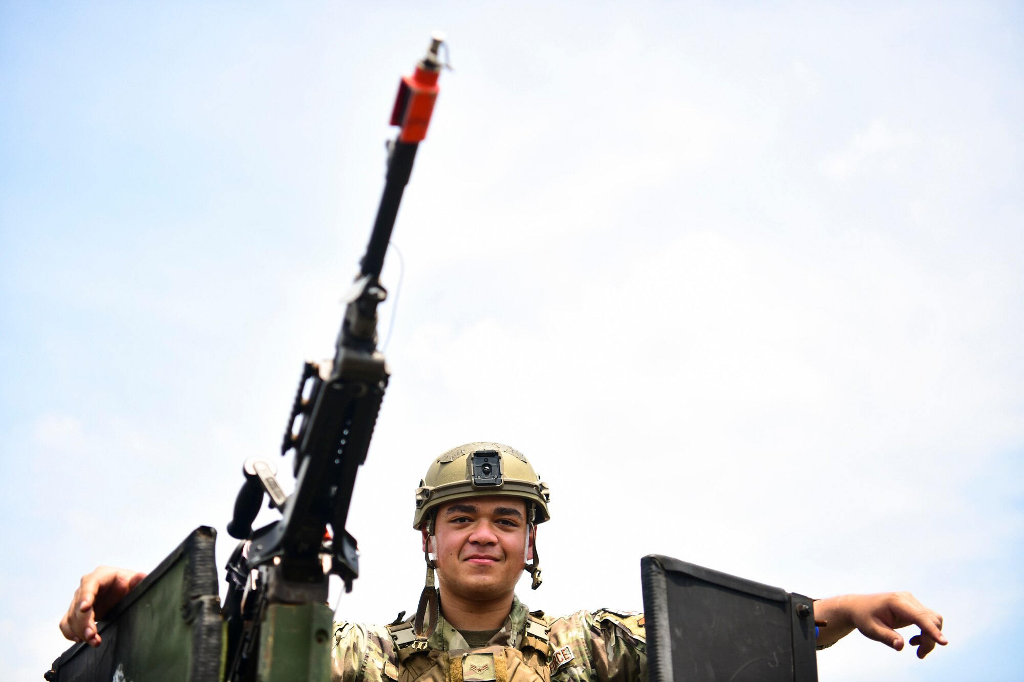An Airman perches on top of a Humvee.