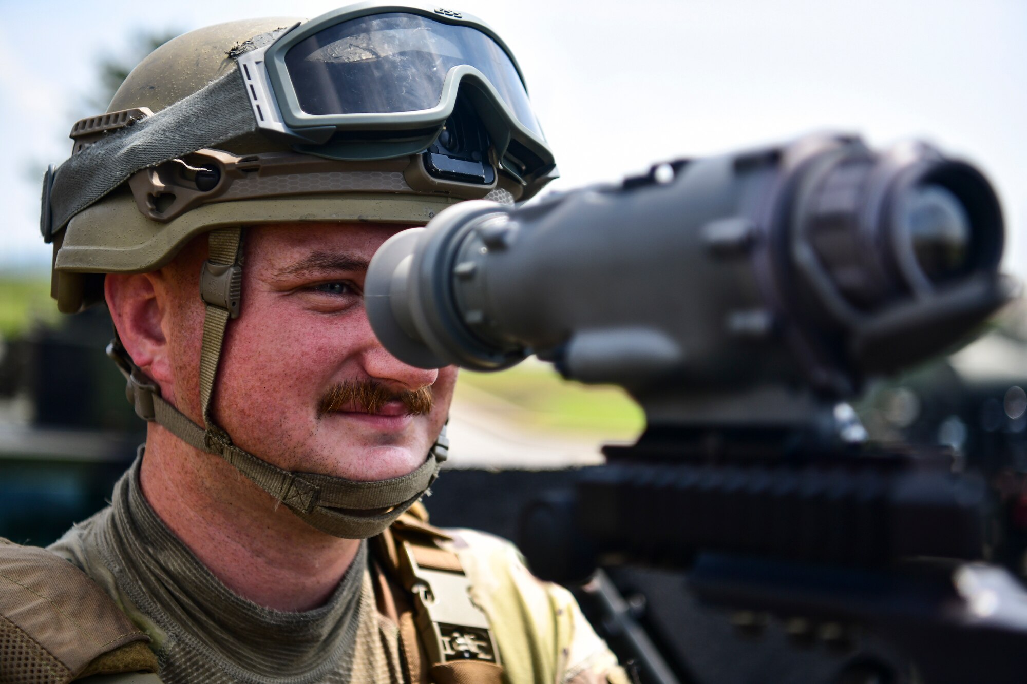 An Airman looks into a machine gun.