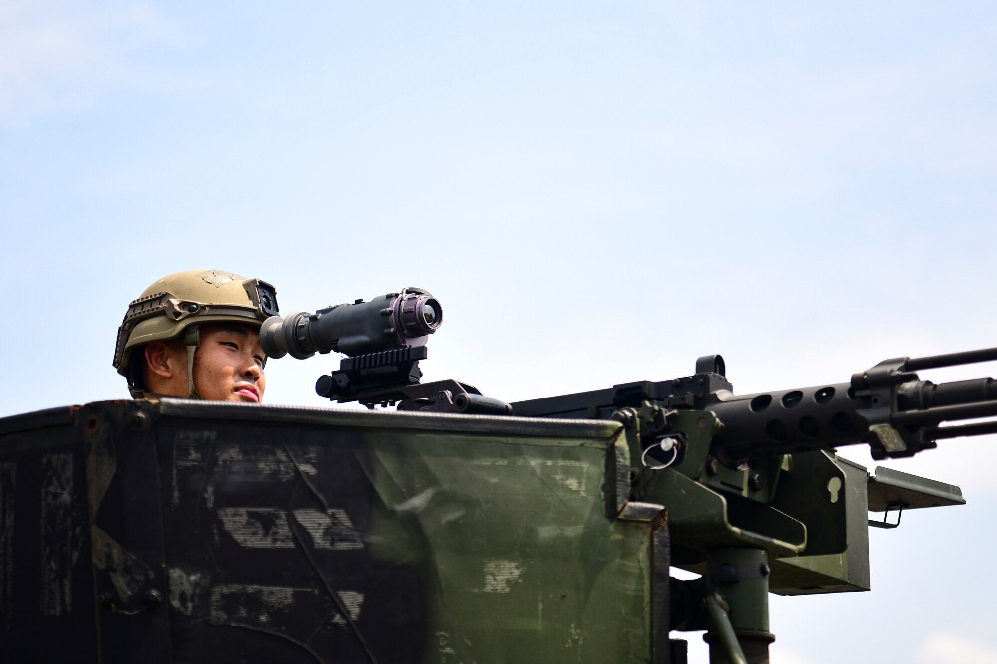 An Airmen looks into a machine gun.