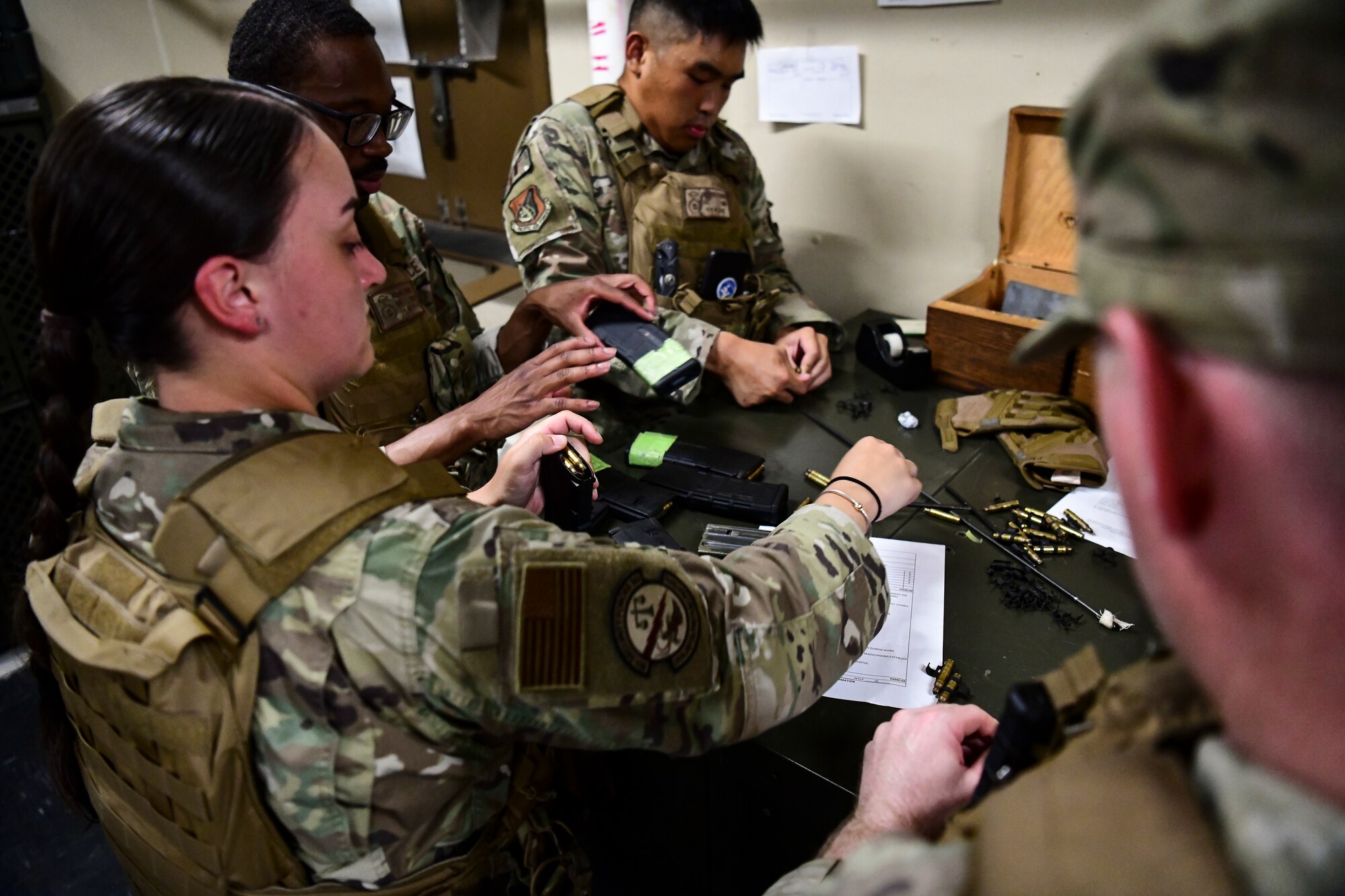 Airmen load magazines with bullets.
