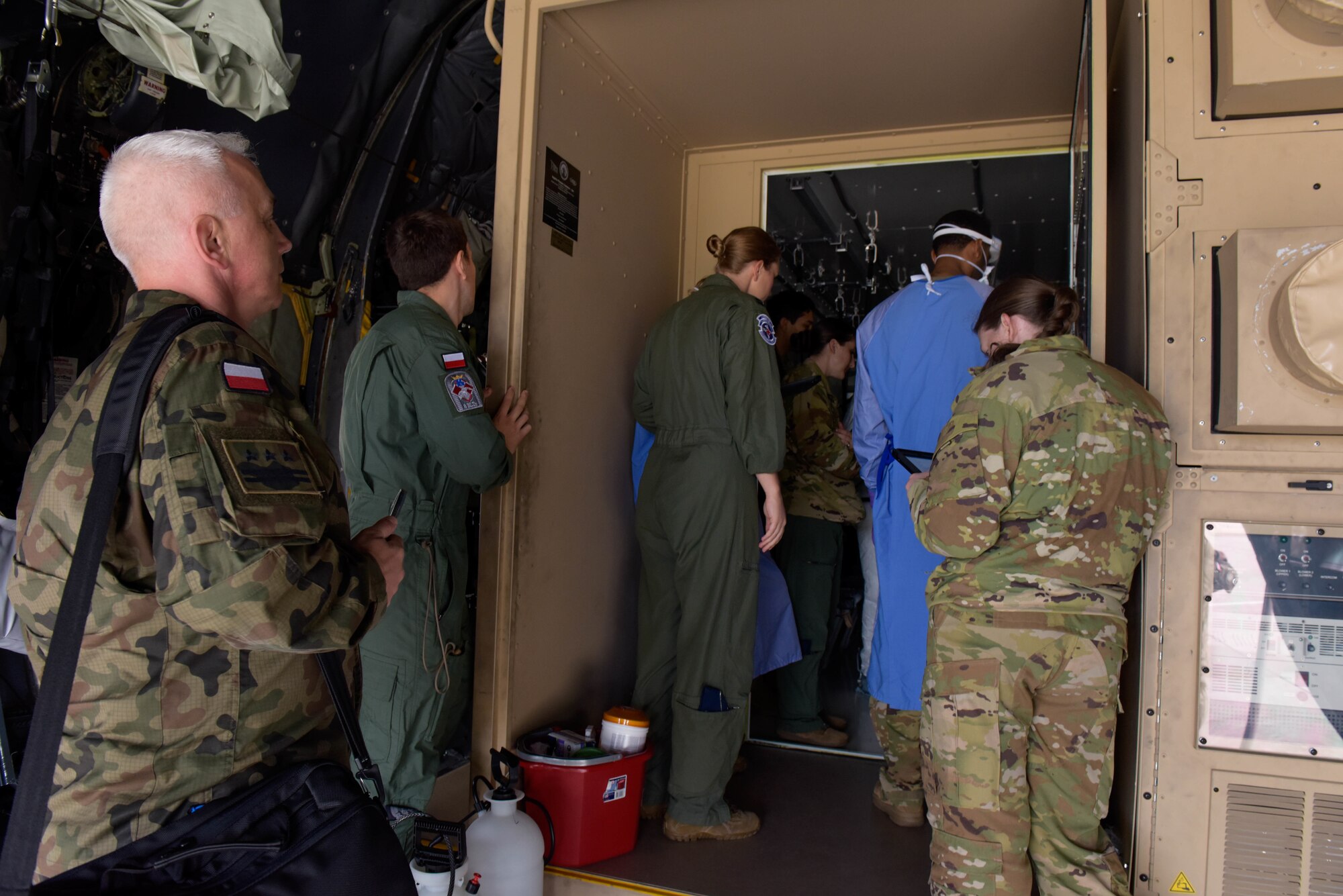 Polish army and air force members observe U.S. Air Force Airmen conducting Negatively Pressured Conex Lite training