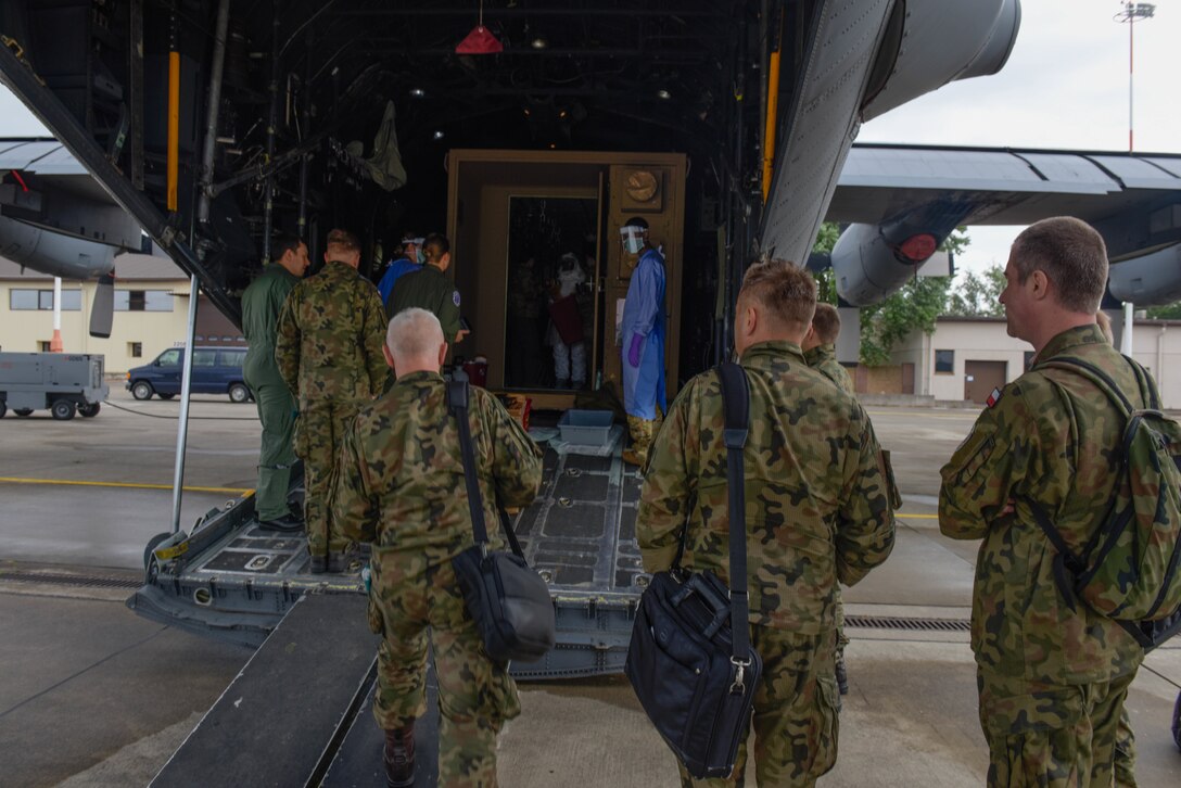 Members of the Polish army and air force observe U.S. Air Force Airmen conducting Negatively Pressurized Conex Lite training