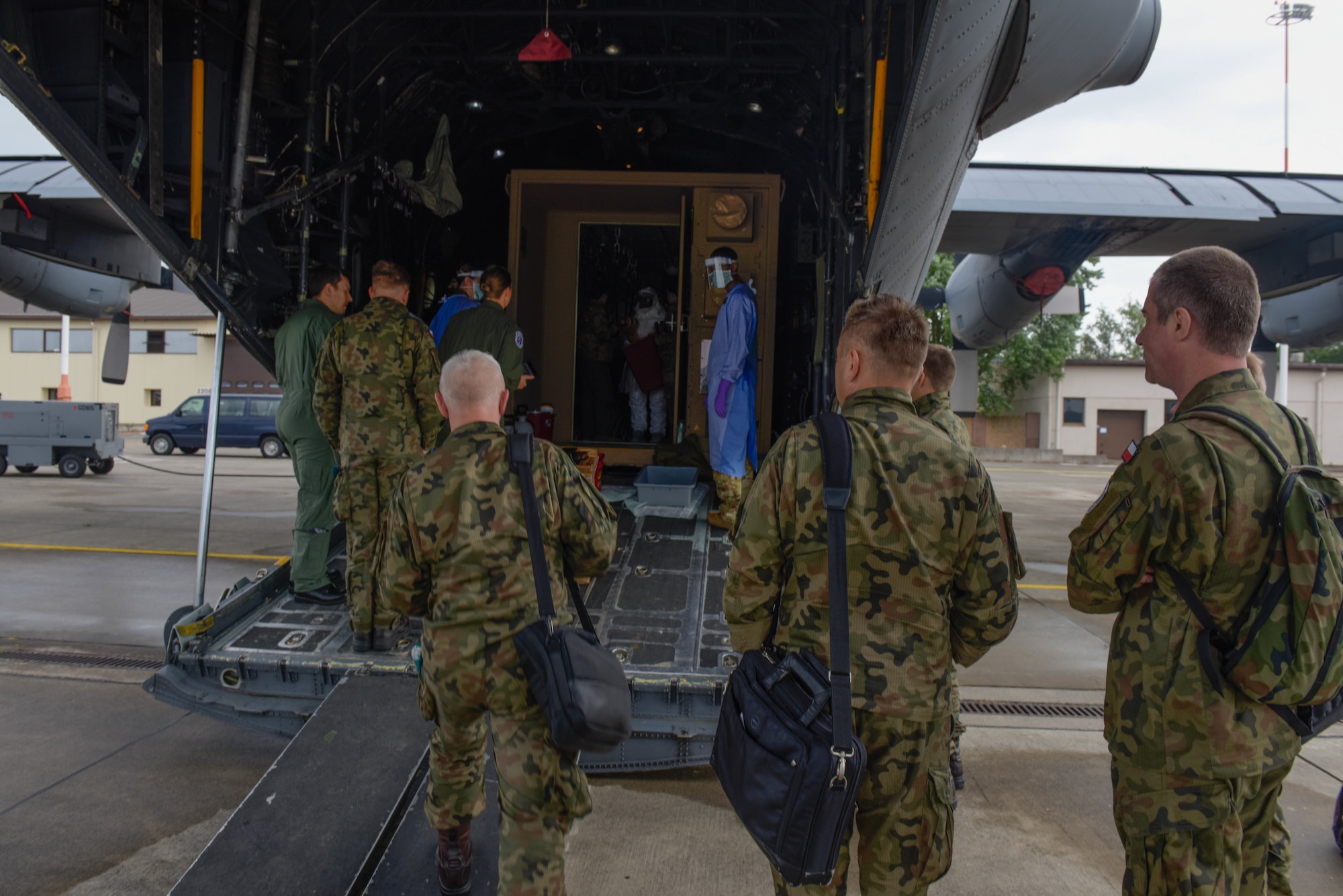 Members of the Polish army and air force observe U.S. Air Force Airmen conducting Negatively Pressurized Conex Lite training