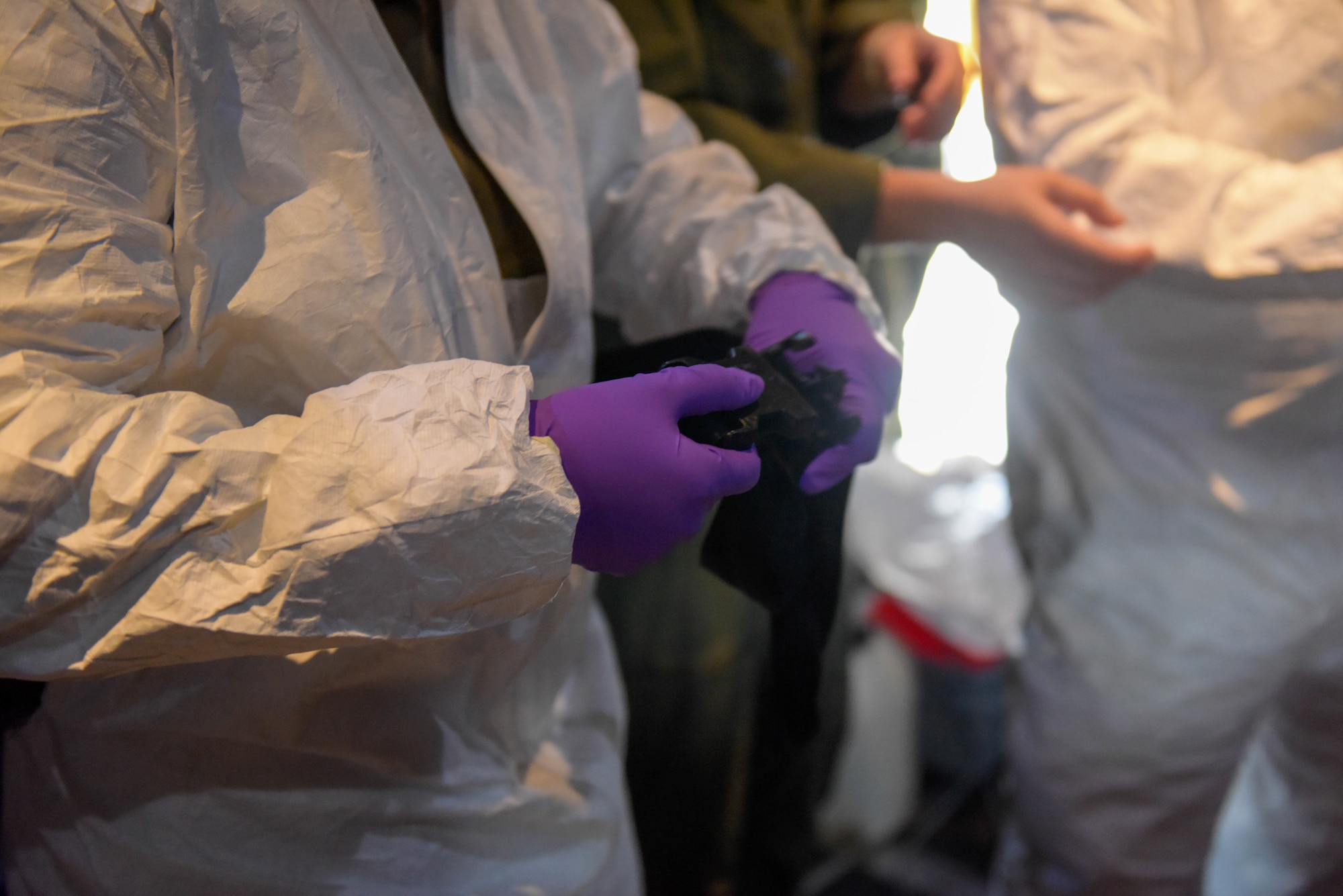 U.S. Air Force Senior Airman Sarah Amato puts on a Tyvek suit