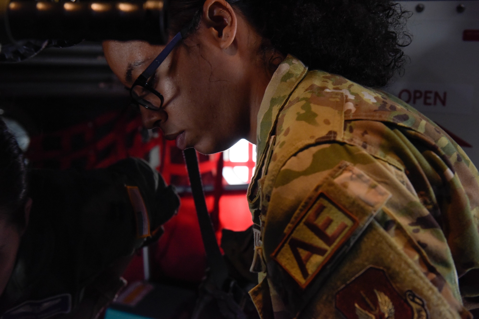 U.S. Air Force Airman attaches ratchet straps to a stretcher