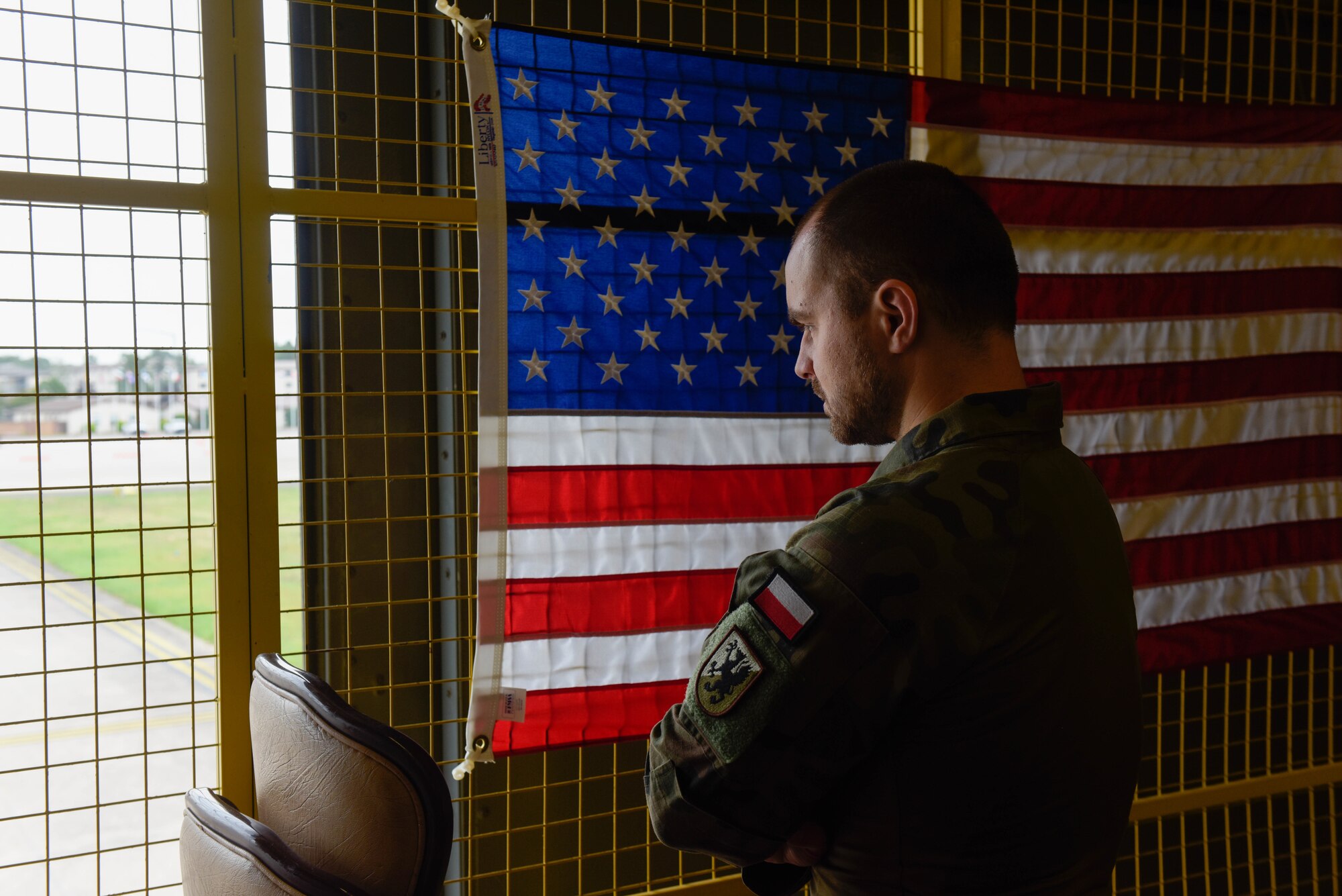 Polish army Lt. looks out of a window overlooking the flightline while visiting Ramstein Air Base, Germany, for Negatively Pressurized Conex Lite training