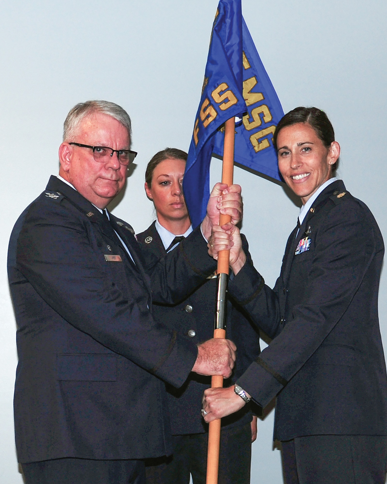 Col. Donald Wren, 445th Mission Support Group commander, passes the guidon to Maj. Miranda Laubie, incoming 445th Force Support Squadron commander, during the 445th FSS Assumption of Command ceremony July 10, 2021. Laubie served as the 445th FSS operations officer before assuming command of the squadron.