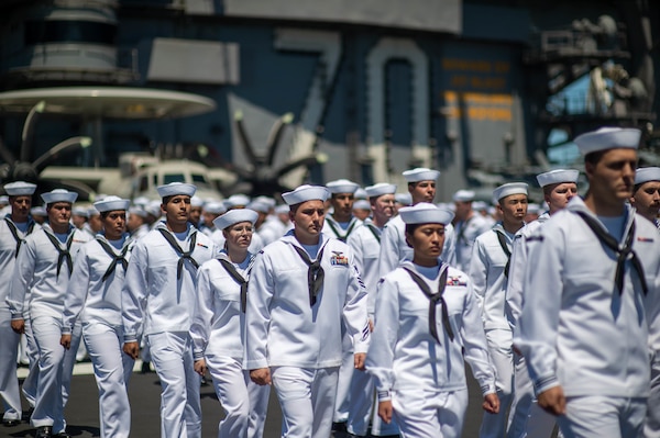 Sailors assigned to the Nimitz-class aircraft carrier USS Carl Vinson (CVN 70) prepare to man the rails on the flight deck.