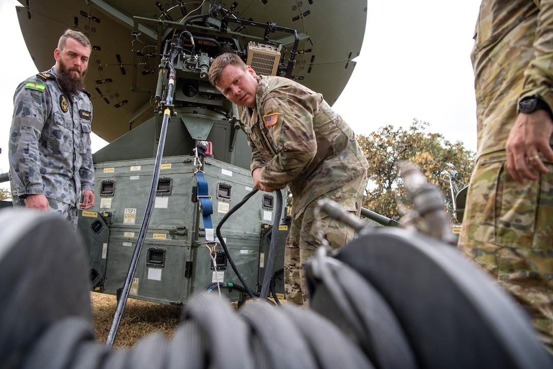 A U.S. service member sets up a communications satellite.