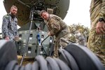 A U.S. service member sets up a communications satellite.