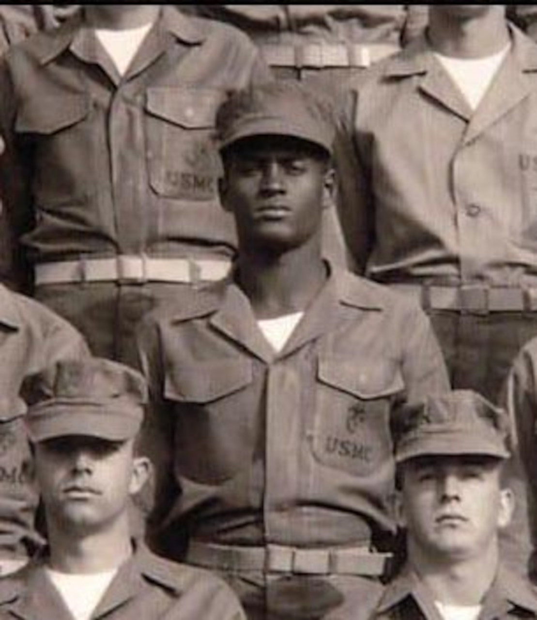A young Marine faces the camera in a group photo.