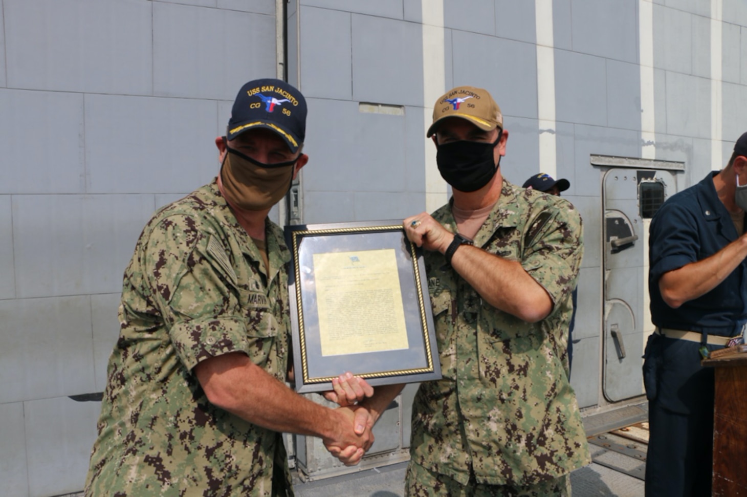 NAVAL STATION NORFOLK (Aug. 2, 2021) – Rear Adm. Brendan McLane, commander, Naval Surface Force Atlantic, presents Capt. Chris Marvin, commanding officer of the guided-missile cruiser USS San Jacinto (CG 56), with the Navy Unit Commendation. The crew of San Jacinto was awarded for their leadership and hard work in support of the Dwight D. Eisenhower Carrier Strike Group during their 2020 deployment, which lasted 206 days with no port visits. (U.S. Navy photo by Boatswain’s Mate 3rd Class Danielle Bordine/Released)