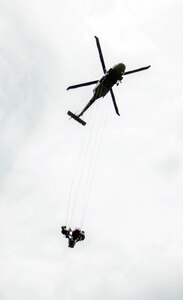A Colombian army UH-60 Black Hawk carries two members of the Colombian army search and rescue team