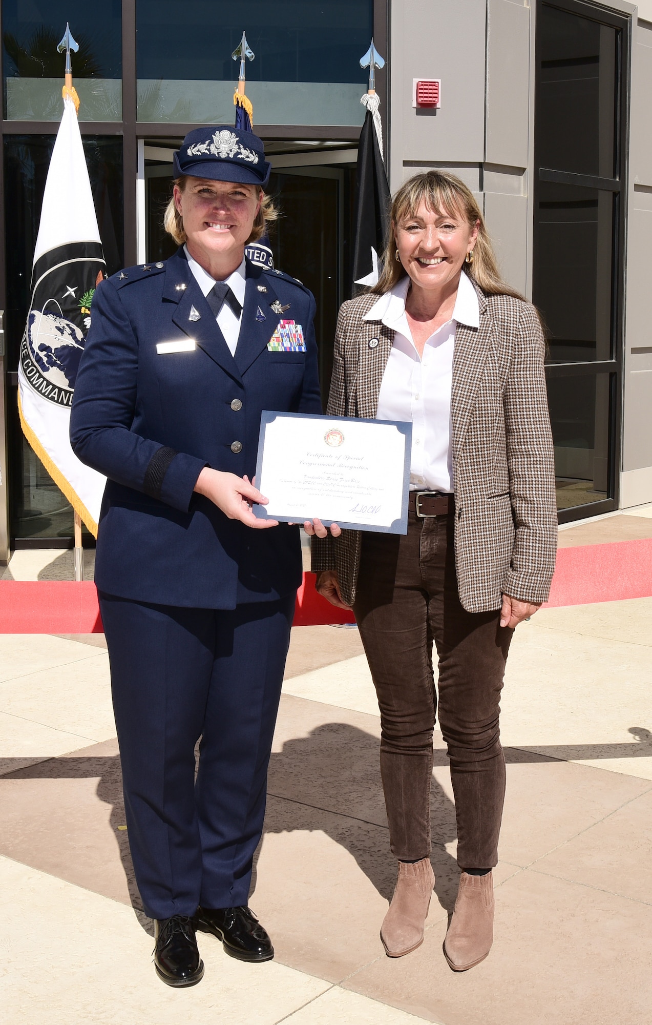Wendy Motta (at right), a representative for Congressman Salud Carbajal (D-Santa Barbara), presents a Certificate of Special Congressional Recognition to Maj. Gen DeAnna Burt, Combined Force Space Component Command commander, at the ribbon-cutting ceremony for the new co-located CFSCC headquarters and Combined Space Operations Center building at Vandenberg Space Force Base, Calif., Aug. 2, 2021.