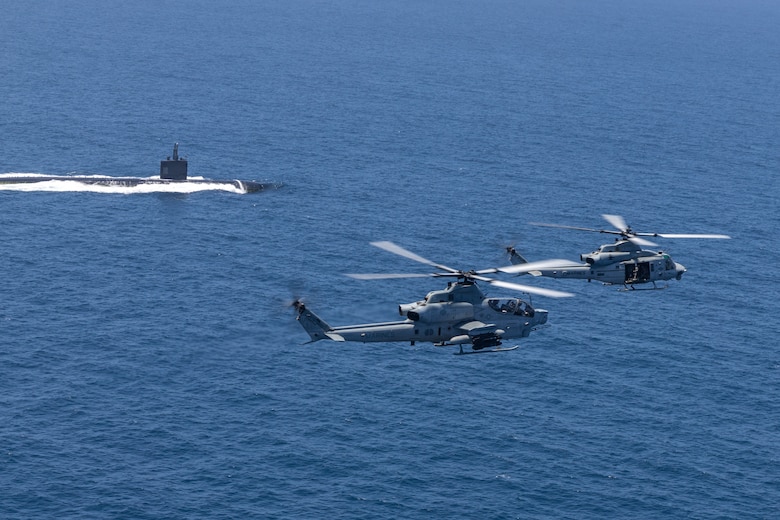 U.S. Marine Corps AH-1Z Viper and UH-1Y Venom with Marine Light Attack Helicopter Squadron 267, Marine Aircraft Group 16, 3rd Marine Aircraft Wing, fly over a U.S. Navy Submarine during Advanced Naval Basing evolution of Summer Fury 21 at San Clemente, California, July 20, 2021. Advanced Naval Basing offering forward logistics and support, as well as sensor and strike capabilities that make a significant contribution to undersea warfare campaigns in the Indo-Pacific region. Summer Fury is an exercise conducted by 3rd MAW in order to maintain and build capability, strength and trust within its units to generate the readiness and lethality needed to deter and defeat adversaries during combat operations as the U.S. Marine Corps refines tactics and equipment in accordance with Force Design 2030.