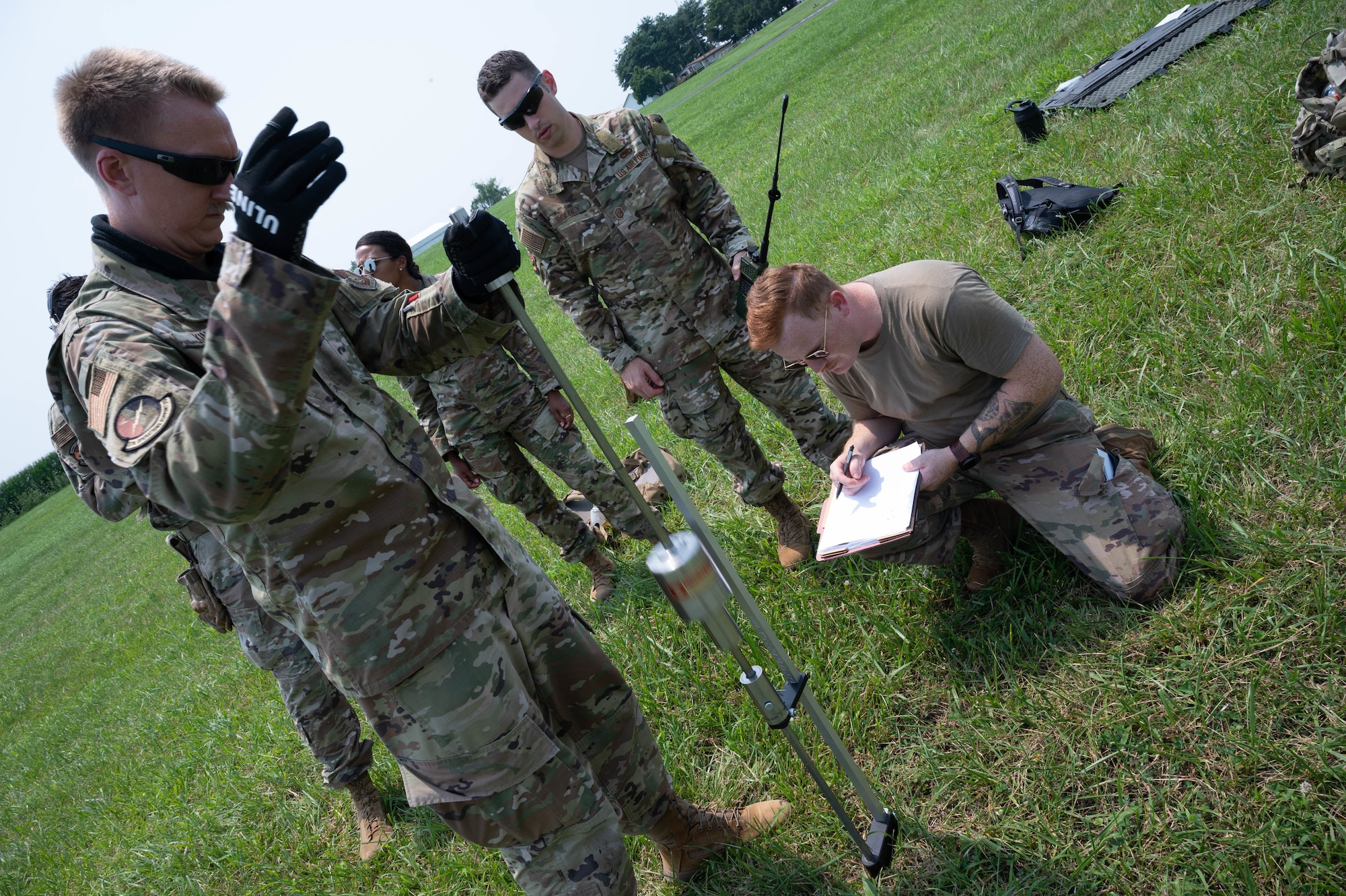 U.S. Air Force Tech. Sgt. James King III and Staff Sgt. Corbin Simonsen, Landing Zone Operations Course students, test the strength of the soil at a simulated landing zone using a dynamic cone penetrometer at Schafer Field in St. Jacob, Illinois, July 30, 2021. As part of the Landing Zone Operations Course students simulate surveying a landing zone.