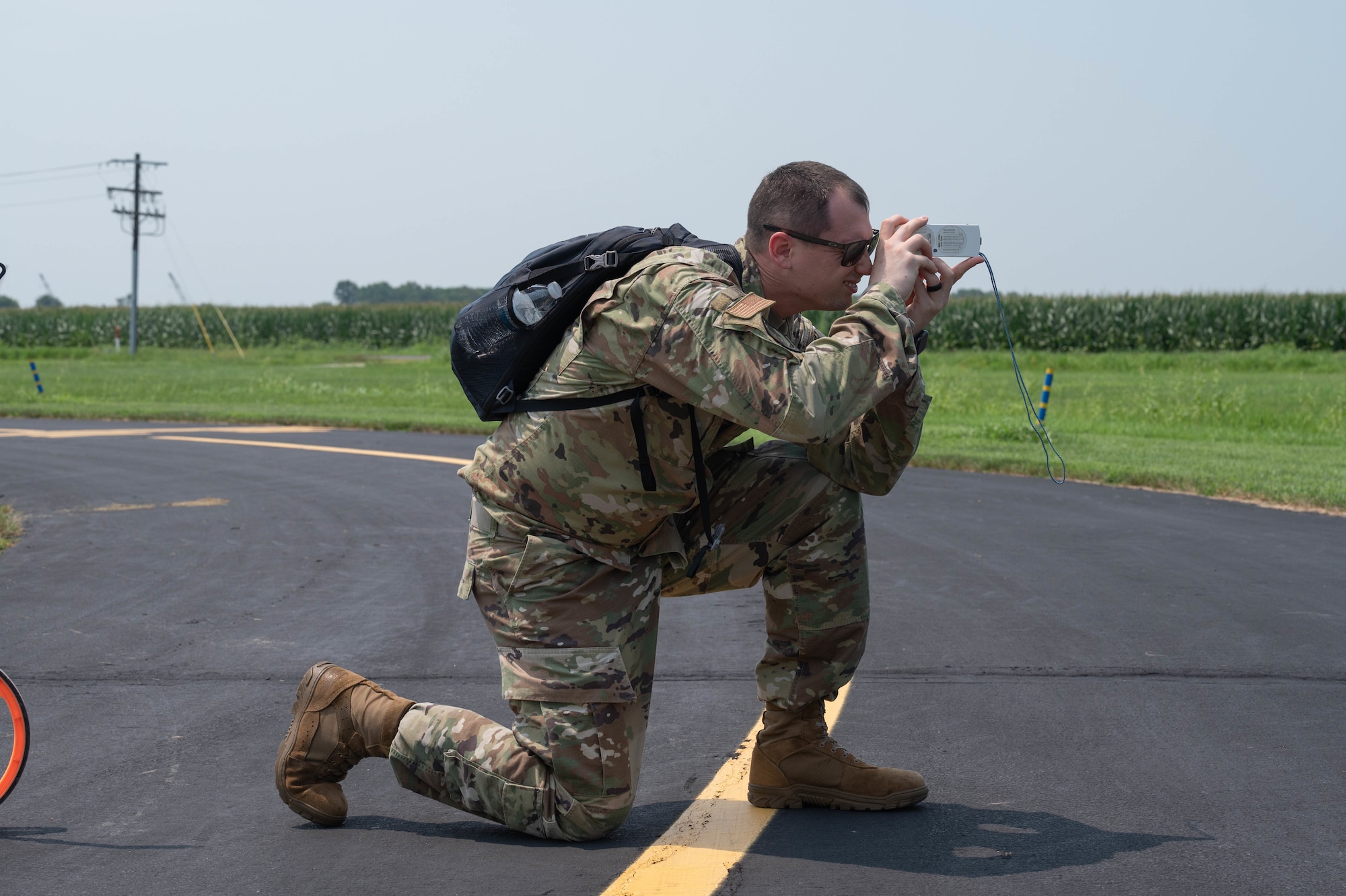 U.S. Air Force Tech. Sgt. Ryan Rathke, Landing Zone Operations Course student, measures the glide slope of a simulated landing zone at Schafer Field in St. Jacob, Illinois, July 30, 2021. As part of the Landing Zone Operations Course students simulate surveying a landing zone.