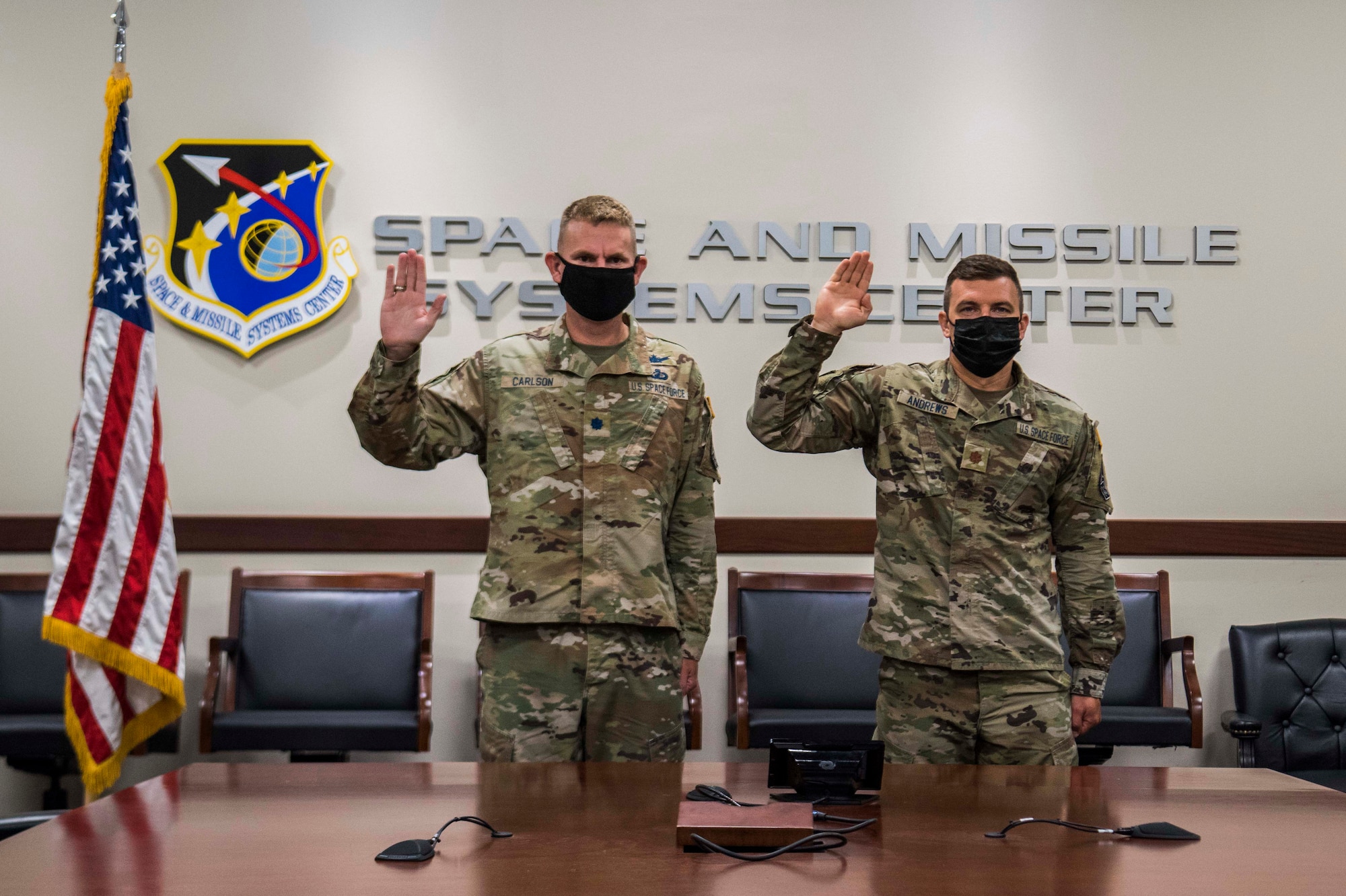 U.S. Space Force Lt. Col. Randall Carlson, Space and Missile Systems Center capability integrator for missile warning, left, and Maj. Christopher Andrews, SMC missile warning enterprise integration chief, perform a ceremonial Oath of Office during a virtual transfer ceremony hosted by U.S. Space Force Chief of Space Operations Gen. John W. “Jay” Raymond, at Los Angeles Air Force Base, California, Aug. 2, 2021. After the Oath of Office was administered, signifying a ceremonial transfer from the U.S. Air Force to the USSF, officers across the globe had the opportunity to engage with Raymond during a town hall. (U.S. Space Force photo by Staff Sgt. Elijah Jackson)