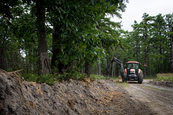 Photo of range support personnel clearing trees during fire break maintenance.