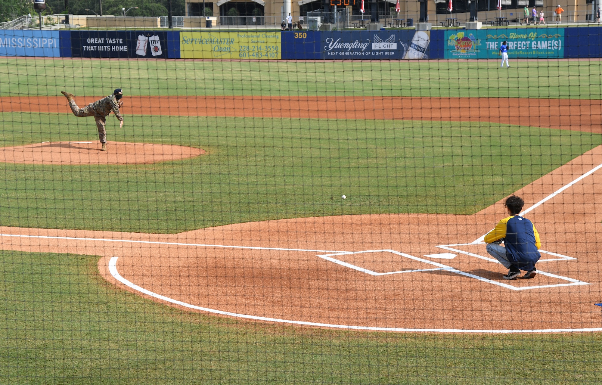 U.S. Air Force Staff Sgt. Cody Garton, 81st Security Forces Squadron military working dog handler, throws out the first pitch at the MGM Park during a Biloxi Shuckers Minor League Baseball team pre-game festivities in Biloxi, Mississippi, Aug. 1, 2021. The "Bark in the Park" themed baseball game invited fans to attend the game with their dogs. (U.S. Air Force photo by Kemberly Groue)