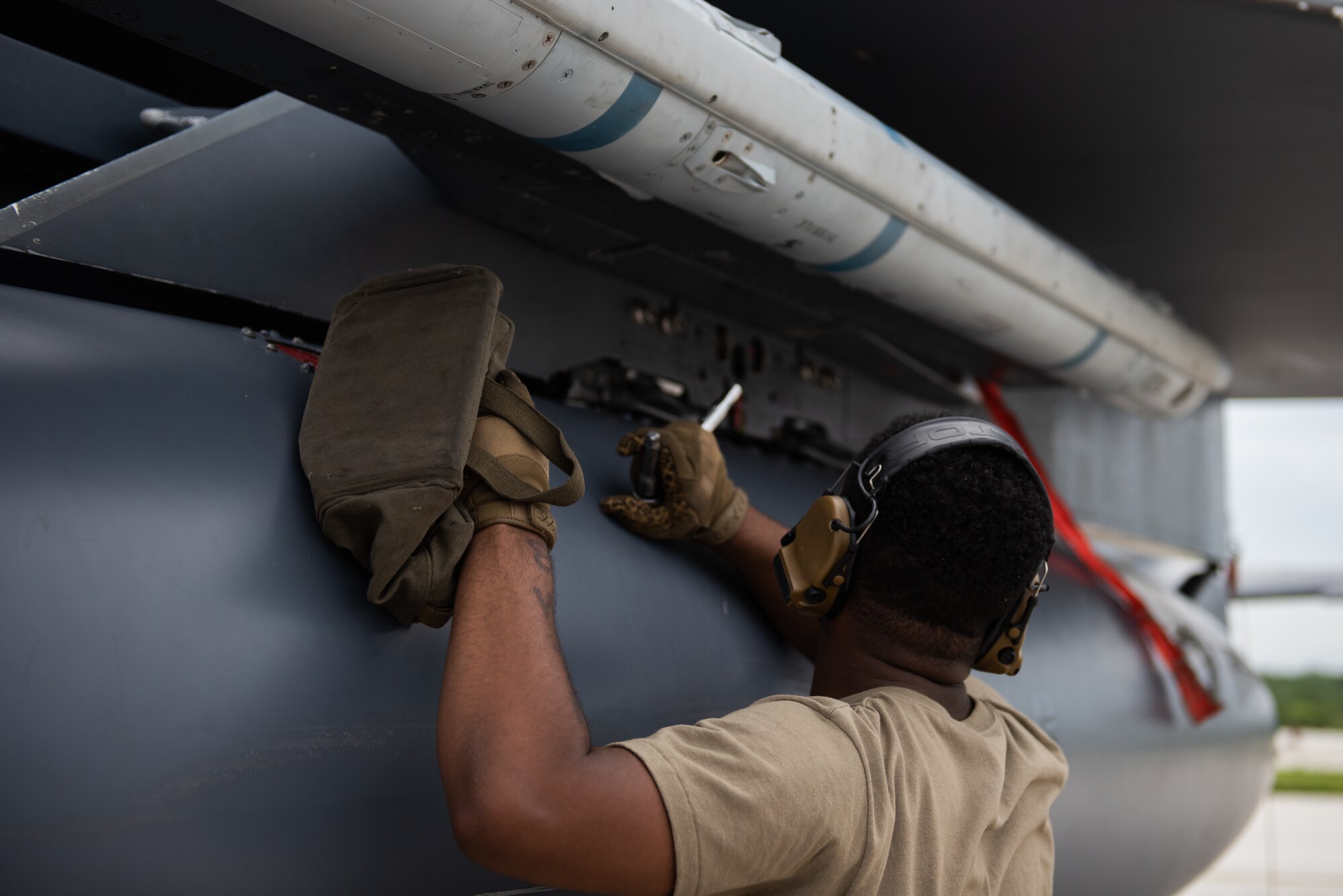 U.S. Air Force Senior Airman Henri Moss, weapons standardization load crew member assigned to the 389th Fighter Squadron, post-loads an AIM-120 while conducting an Integrated Combat Turn on Andersen Air Force Base, Guam, July 24, 2021. Performing ICTs decreases the aircrews' time on the ground and increases the Air Force's ability to meet new challenges in dynamic environments. (U.S. Air Force photo by Airman 1st Class Andrea Rozoto)