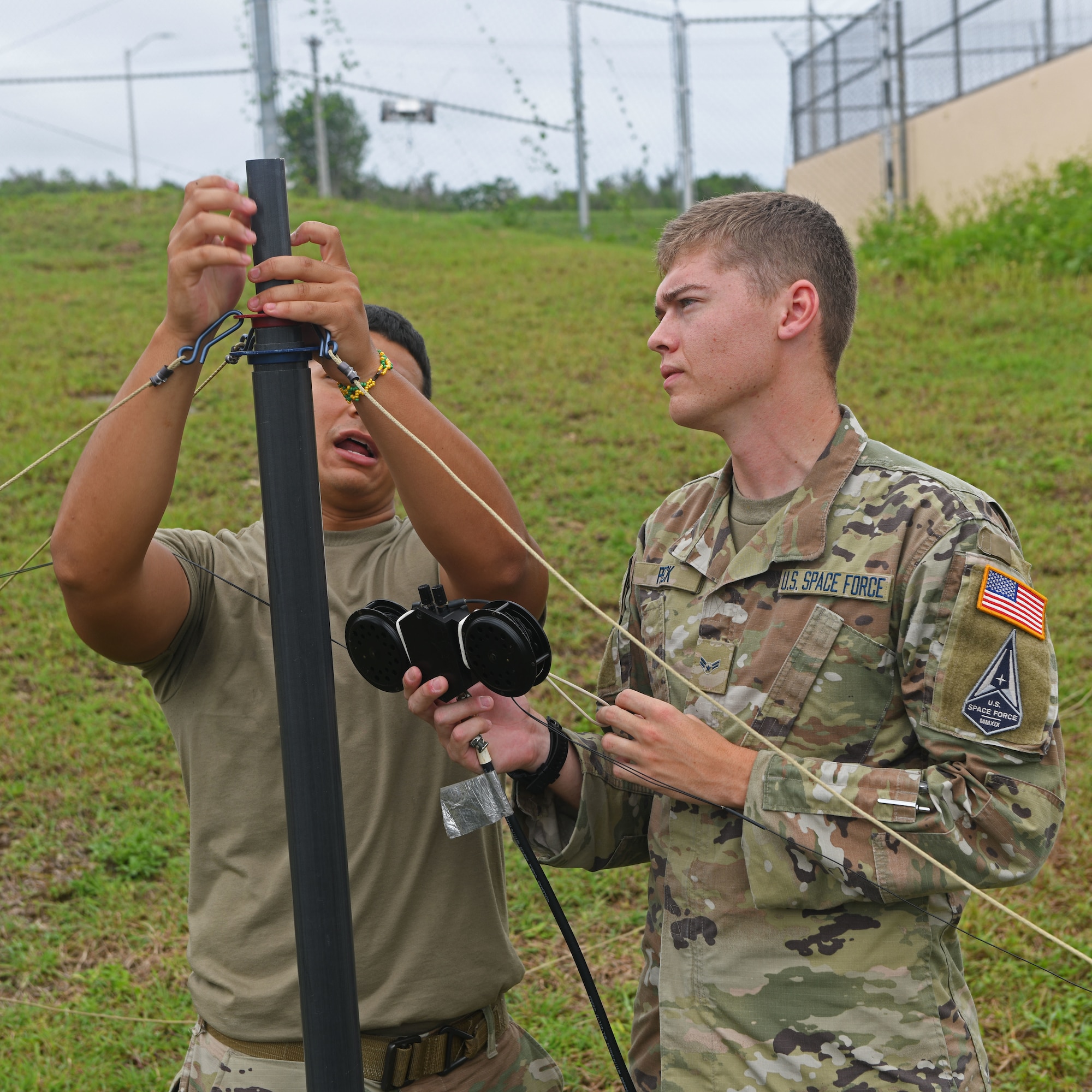 U.S. Air Force Airman 1st Class Brayan Rivera, 644th Combat Communications Squadron, deployed from Andersen Air Force Base, Guam, radio frequency transmissions systems administrator, and U.S. Space Force Specialist 3 Cameron Pack, 644th CBCS, cyber systems operations technician, set up an antenna at the Tinian International Airport, Tinian, during Pacific Iron 2021, Aug. 2, 2021. Pacific Iron 2021 is a Pacific Air Forces dynamic force employment operation to project forces into USINDOPACOM’s area of responsibility in support of the 2018 National Defense Strategy which called on the military to be a more lethal, adaptive, and resilient force. (U.S. Air Force photo by Tech. Sgt. Benjamin Sutton)