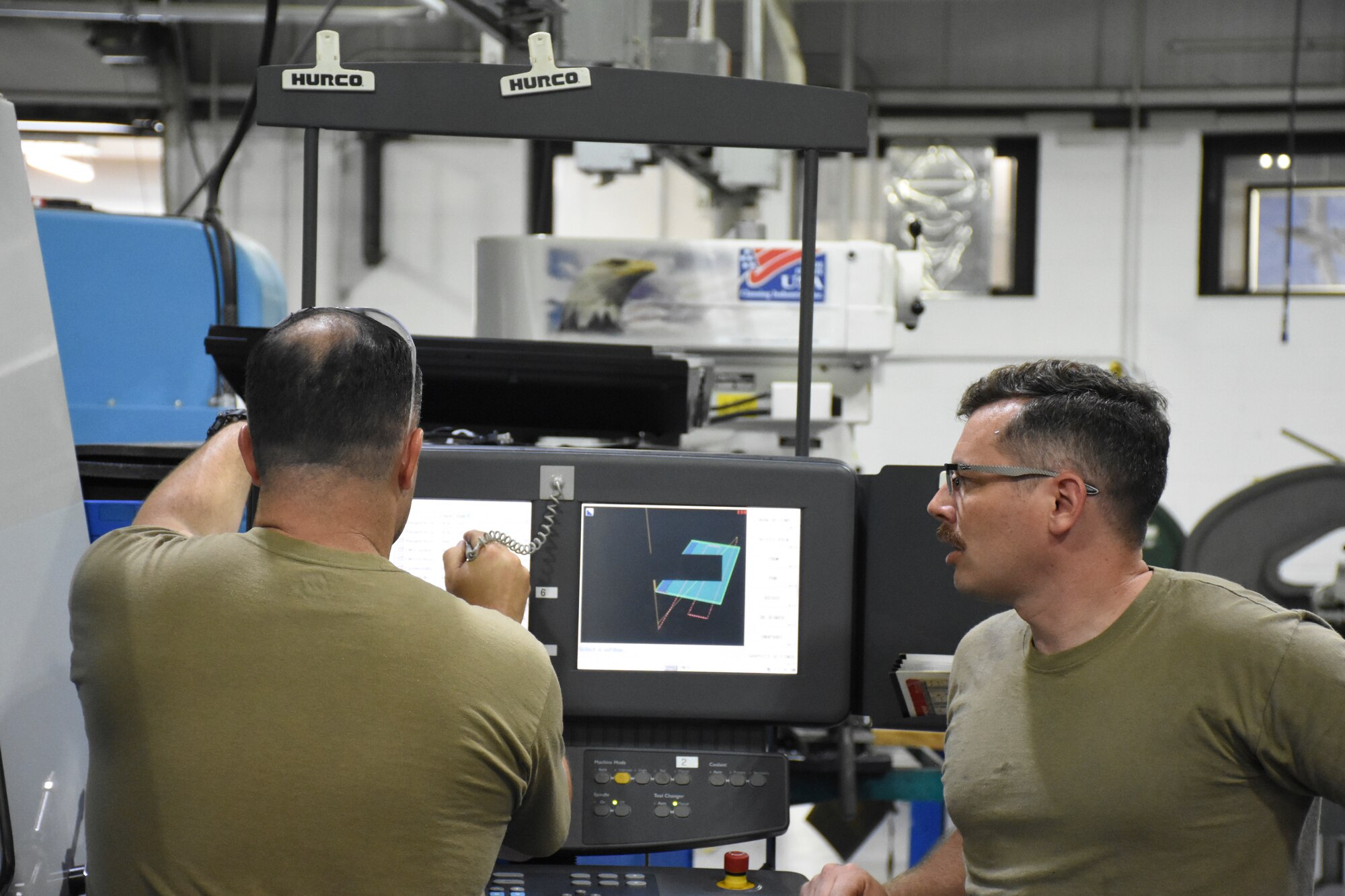 Master Sgt. Cameron Williams, left, and Staff Sgt. Johnathan Shellhart, both machinists with the 442d Maintenance Squadron, design a part on computer-aided drafting software.