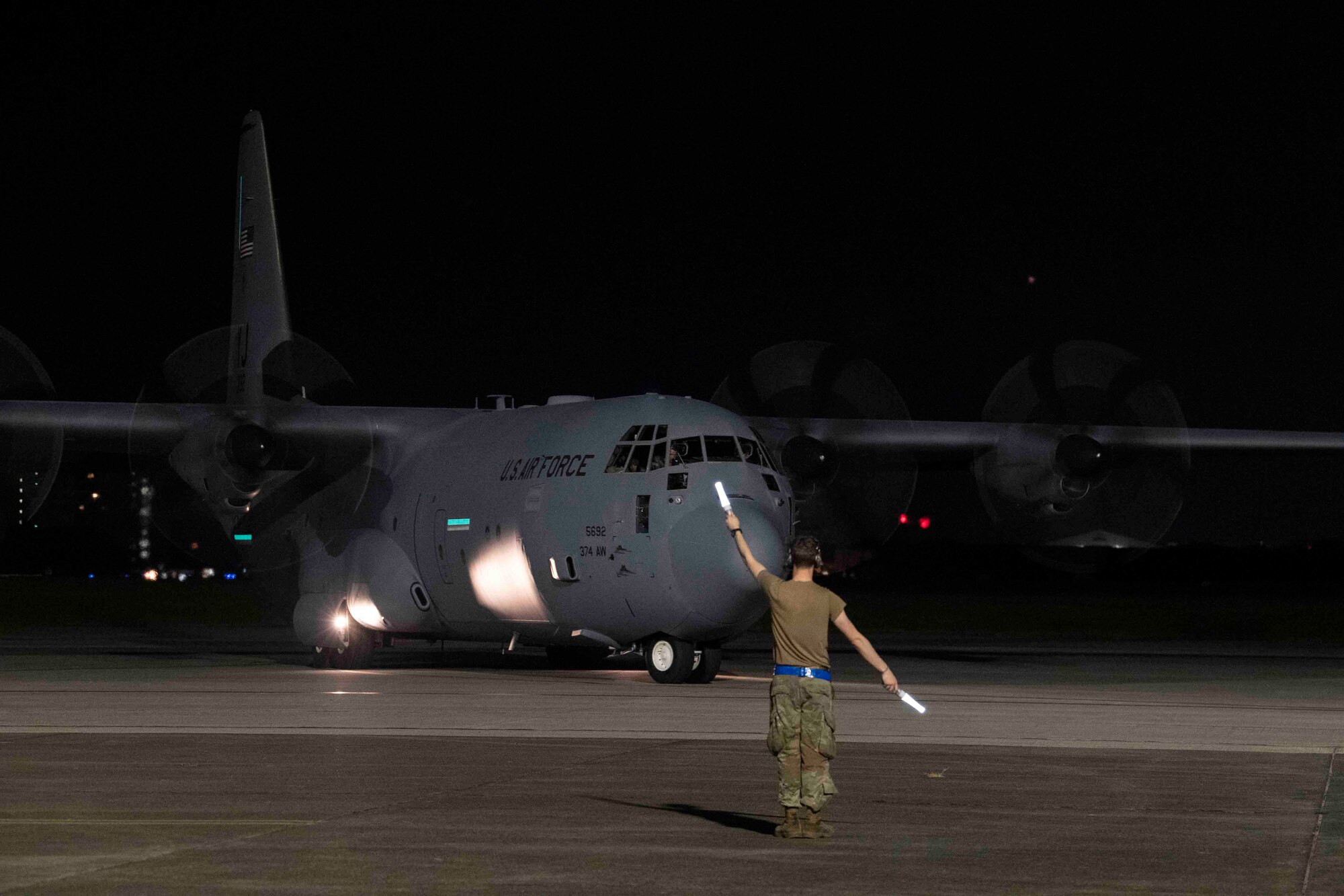 An Airman with the 36th Airlift Squadron directs a C-130J Super Hercules prior to take off during Exercise Forager 21 at Yokota Air Base, Japan, July 29, 2021.