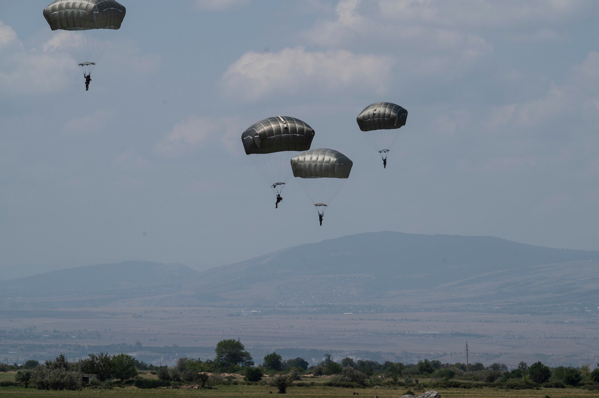U.S. Army soldiers assigned to the 1st Squadron, 91st Cavalry Regiment, 173rd infantry brigade combat team (airborne) and Georgian military personnel prepare to land at a dropzone after static-line jumping from a U.S. Air Force C-130J Super Hercules aircraft during exercise Agile Spirit 21