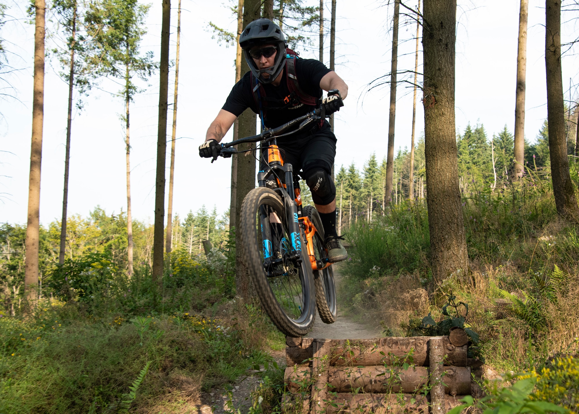 U.S. Air Force Senior Airman Dylan Beck, 52nd Civil Engineer Squadron explosive ordnance disposal team member, propels off a ramp at Mehring Trail Park in Mehring, Germany, July 23, 2021. Beck met some of his closest friends through the sport of mountain biking and rides as often as he can. (U.S. Air Force photo by Staff Sgt. Chance Nardone)