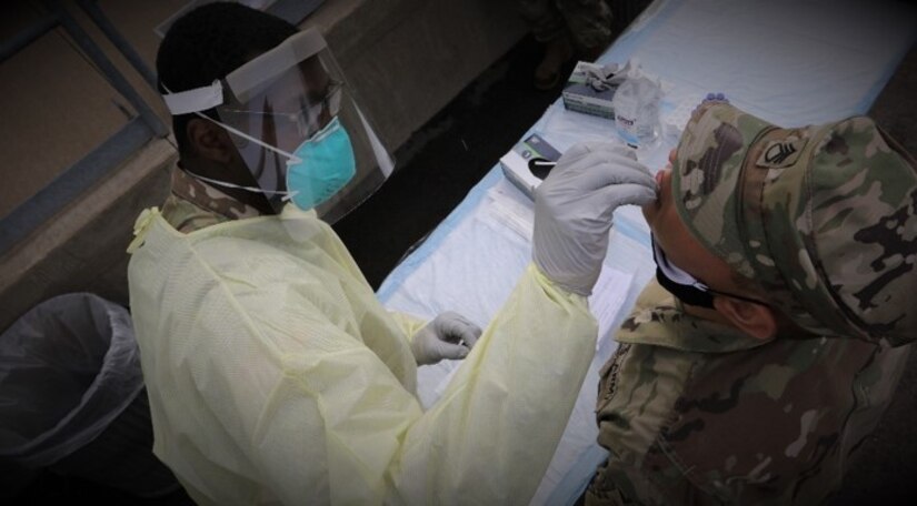 A combat medic specialist with the 329th Medical Company from Fairview, Pa performs BinaxNOW testing on a deploying soldier during Pershing Strike 21 at Fort McCoy, Wis.
