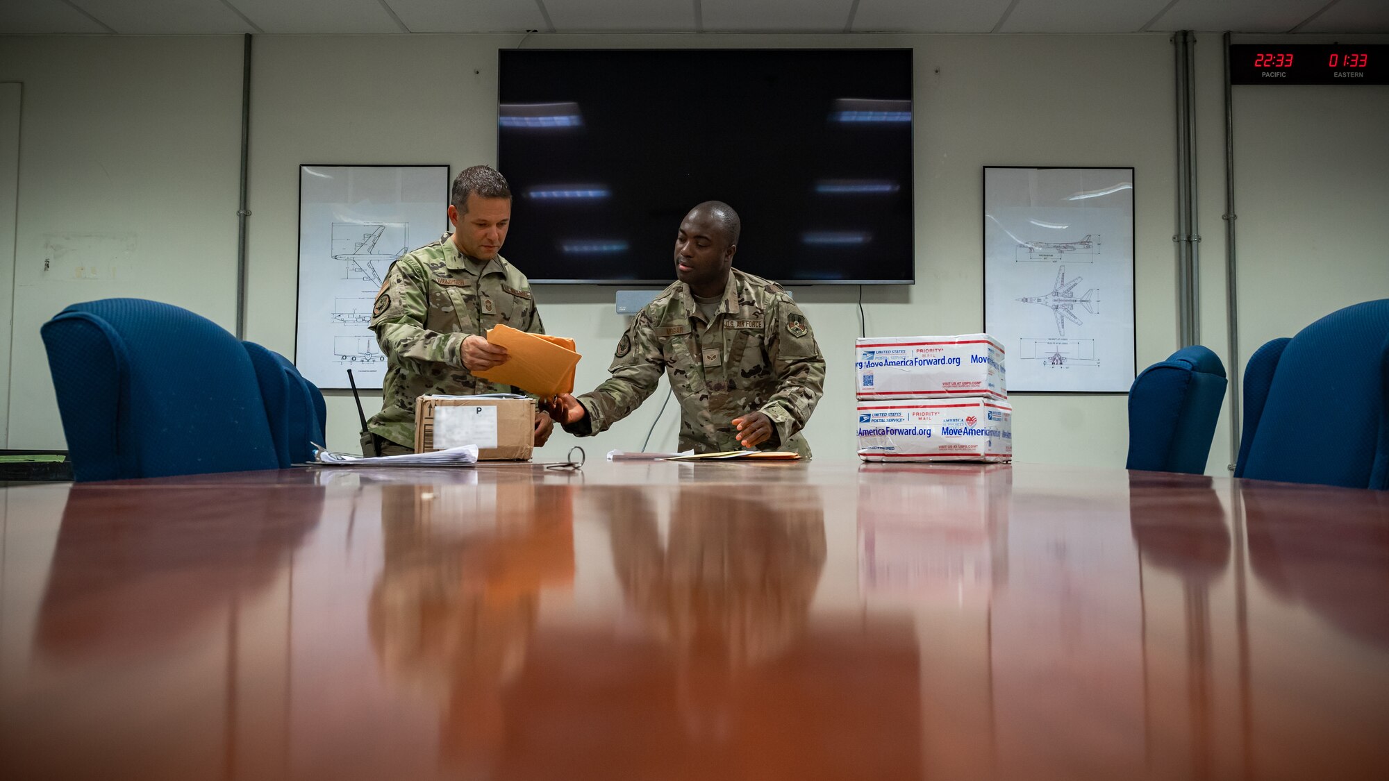 Senior Airman Ajay Vogar, 379th Expeditionary Maintenance Squadron commander support staff security manager, hands a piece of mail to Chief Master Sgt. Jason Thompson, 379th EMXS lead production superintendent at Al Udeid Air Base, Qatar, July 27, 2021.